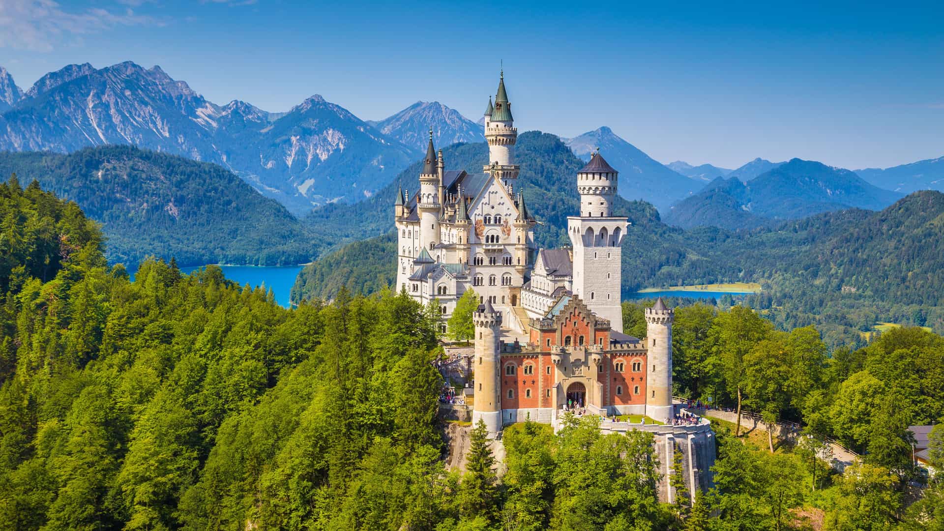 "A beautiful fairy-tale panoramic shot of the historic Neuschwanstein Castle, nestled on a hill above the Hohenschwangau valley in Bavaria, Germany. "