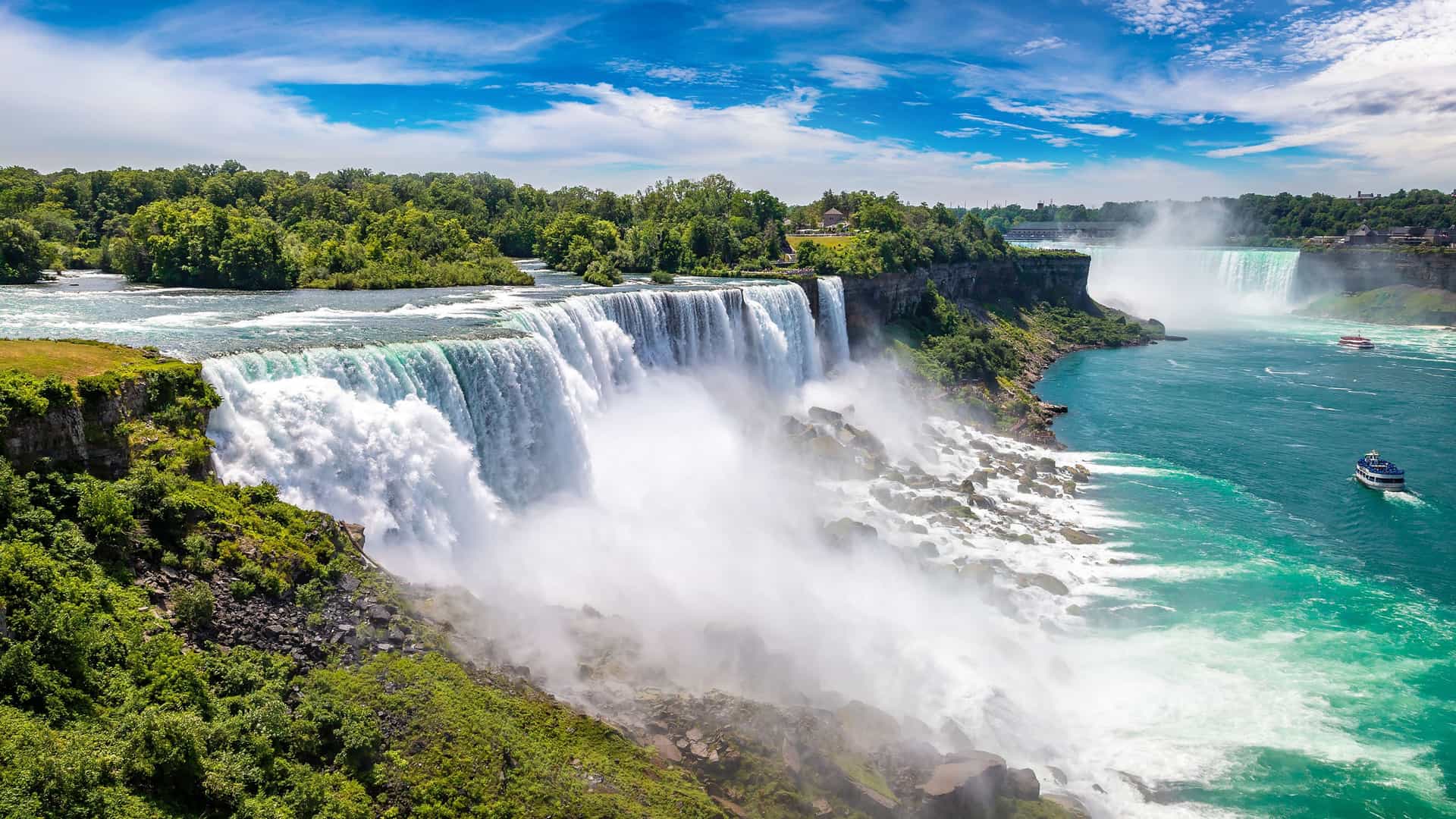 "A panoramic view of the majestic Niagara Falls from the New York side, showing the powerful American Falls cascading into the Niagara River.  "