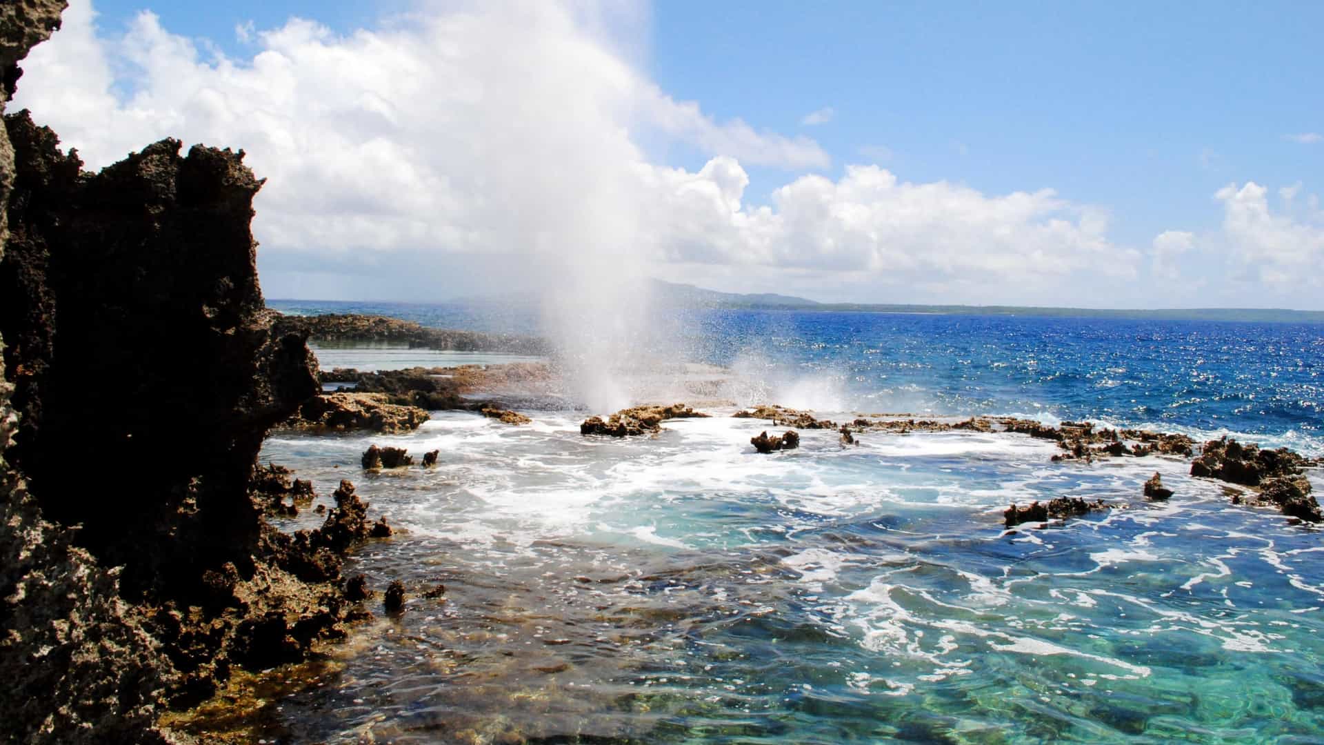 A powerful spouting horn sprays water high into the air from the rocky volcanic coastline of Pagan, Northern Mariana Islands.