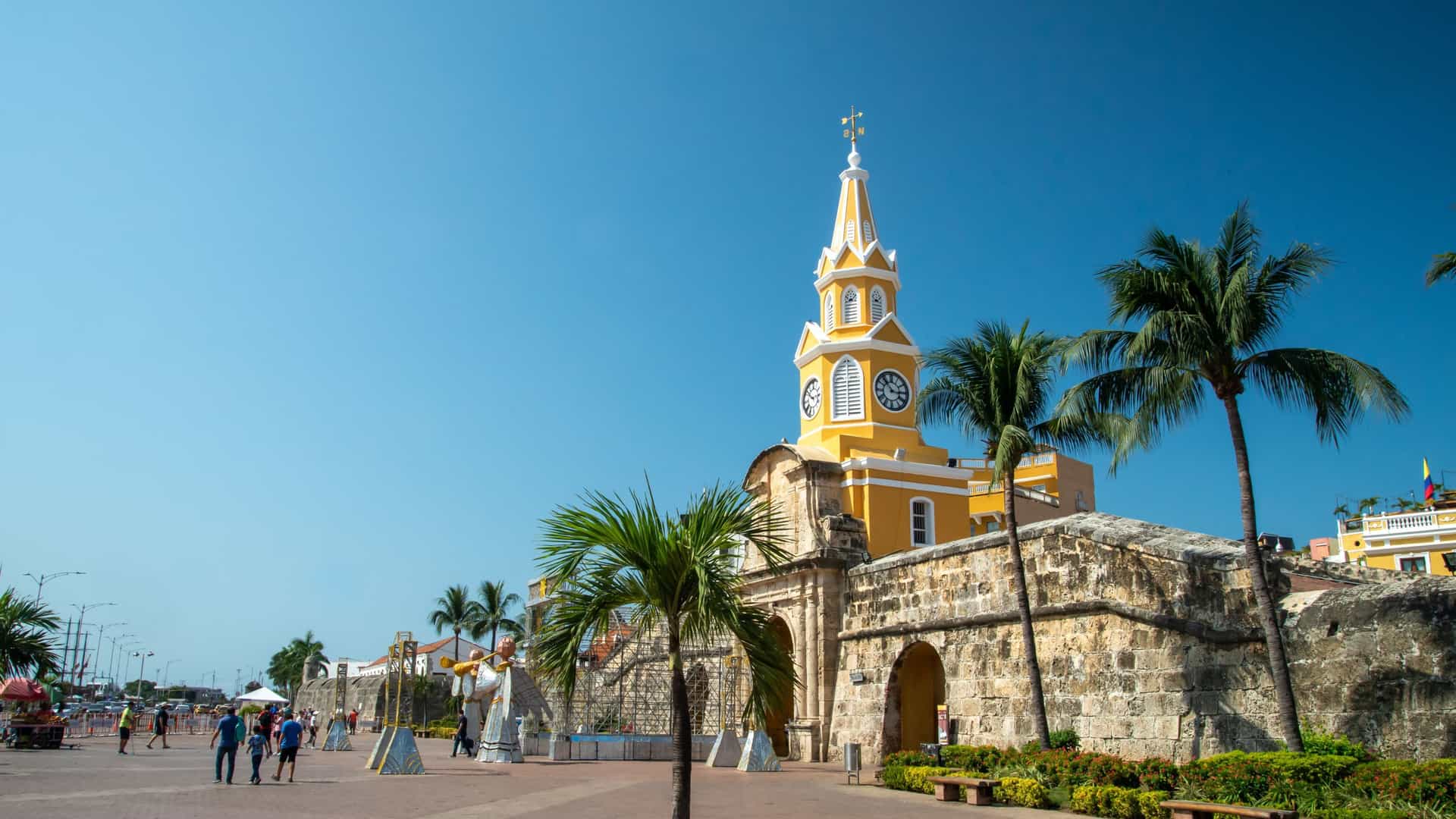 The iconic yellow and white Clock Tower stands above the stone fortifications in the historic Spanish colonial town of Cartagena.