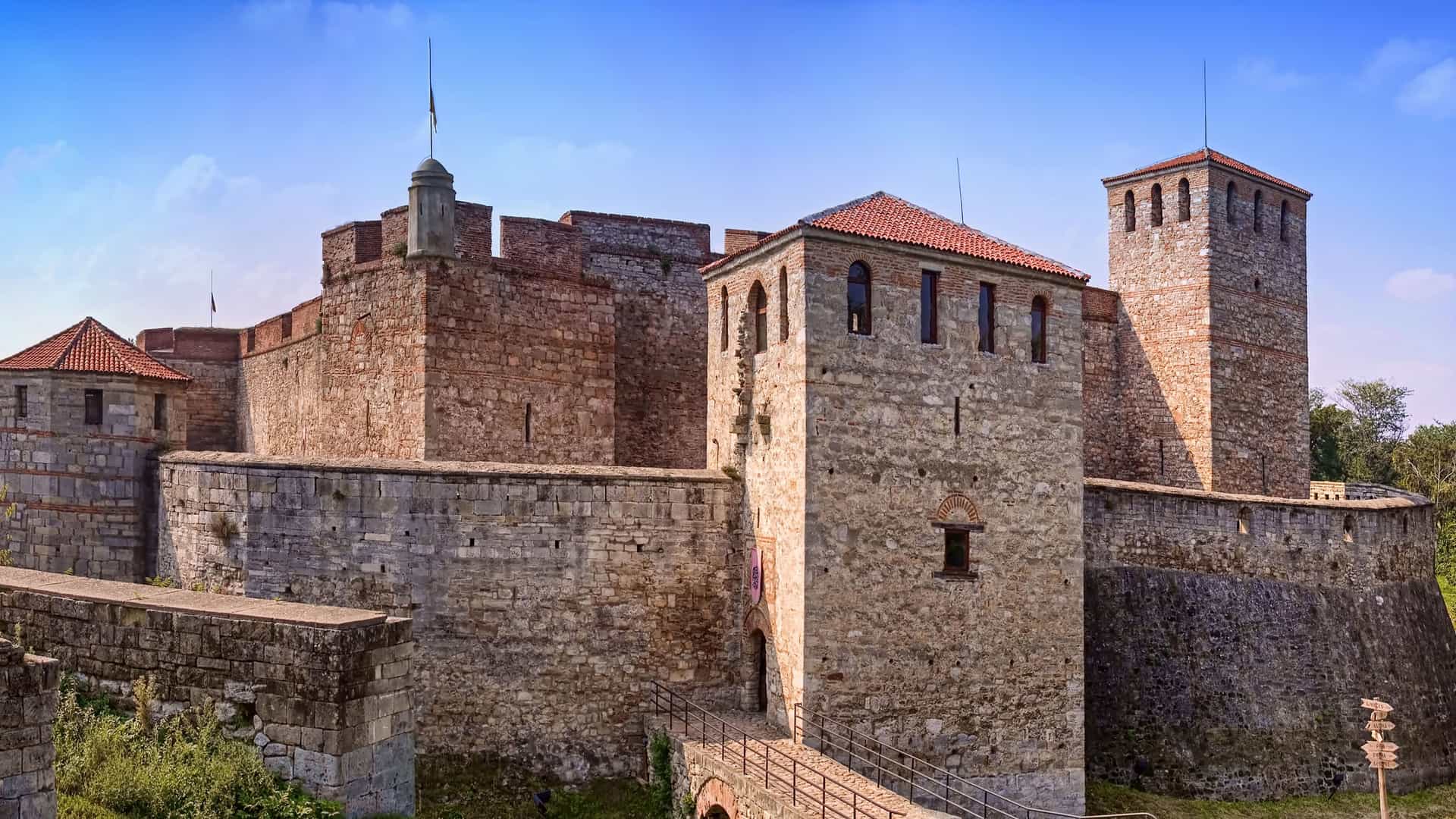 A historic view of the Baba Vida Fortress, a medieval castle with thick stone walls and towers, a major landmark in Vidin, Bulgaria, under a blue sky.