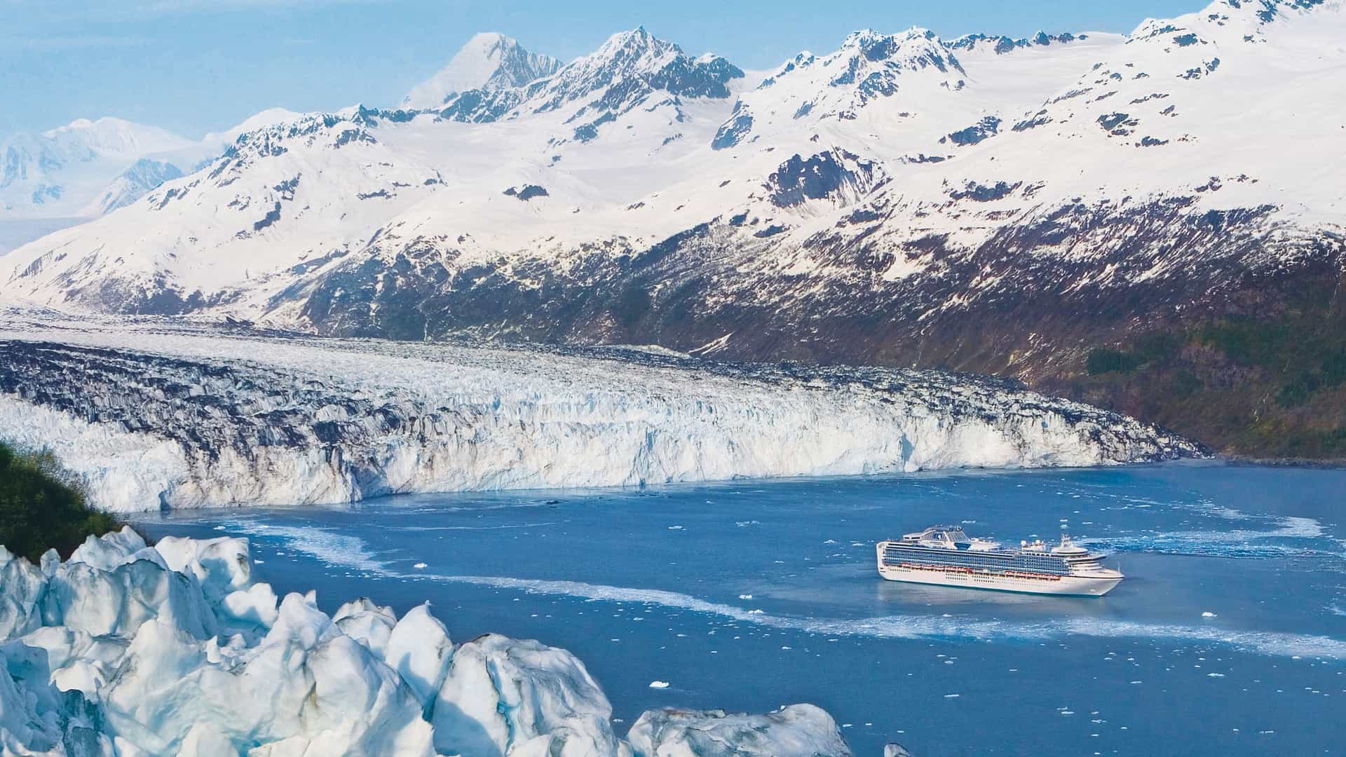 A Princess cruise ship sailing through an Alaskan bay, offering stunning views of massive glaciers and snow-capped mountains.