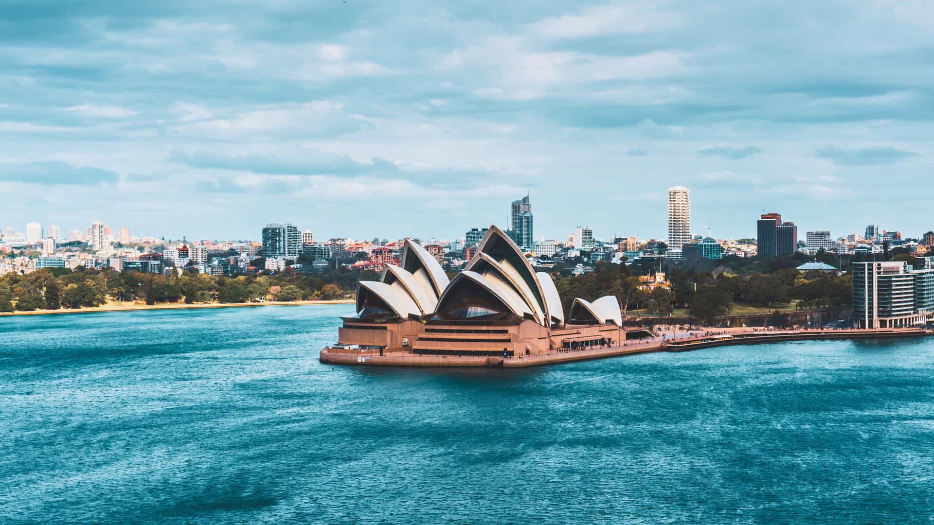 Regent Seven Seas cruise view of the iconic Sydney Opera House against the city skyline in Sydney, Australia.