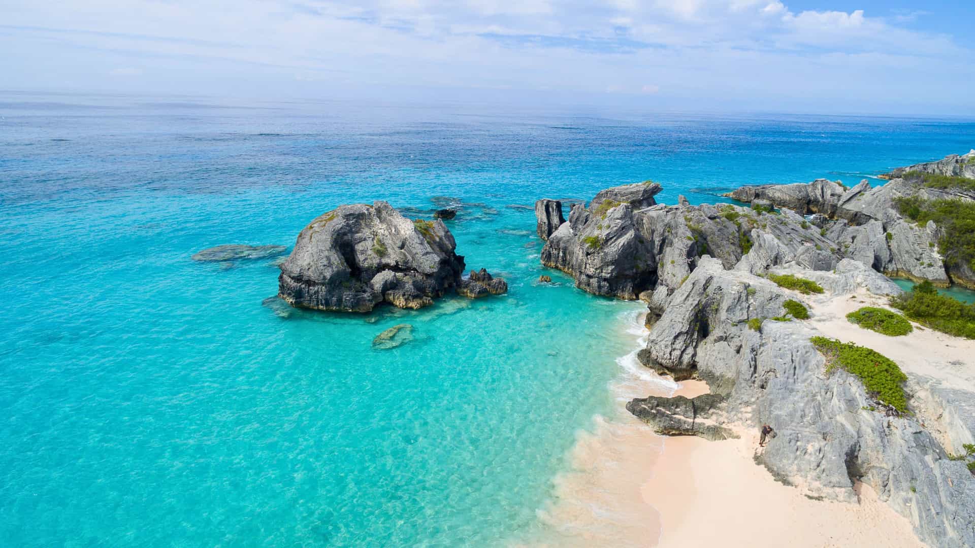 An aerial view of the stunning pink sand beach and turquoise waters of Horseshoe Bay in Bermuda, a beautiful port of call on a Royal Caribbean cruise.