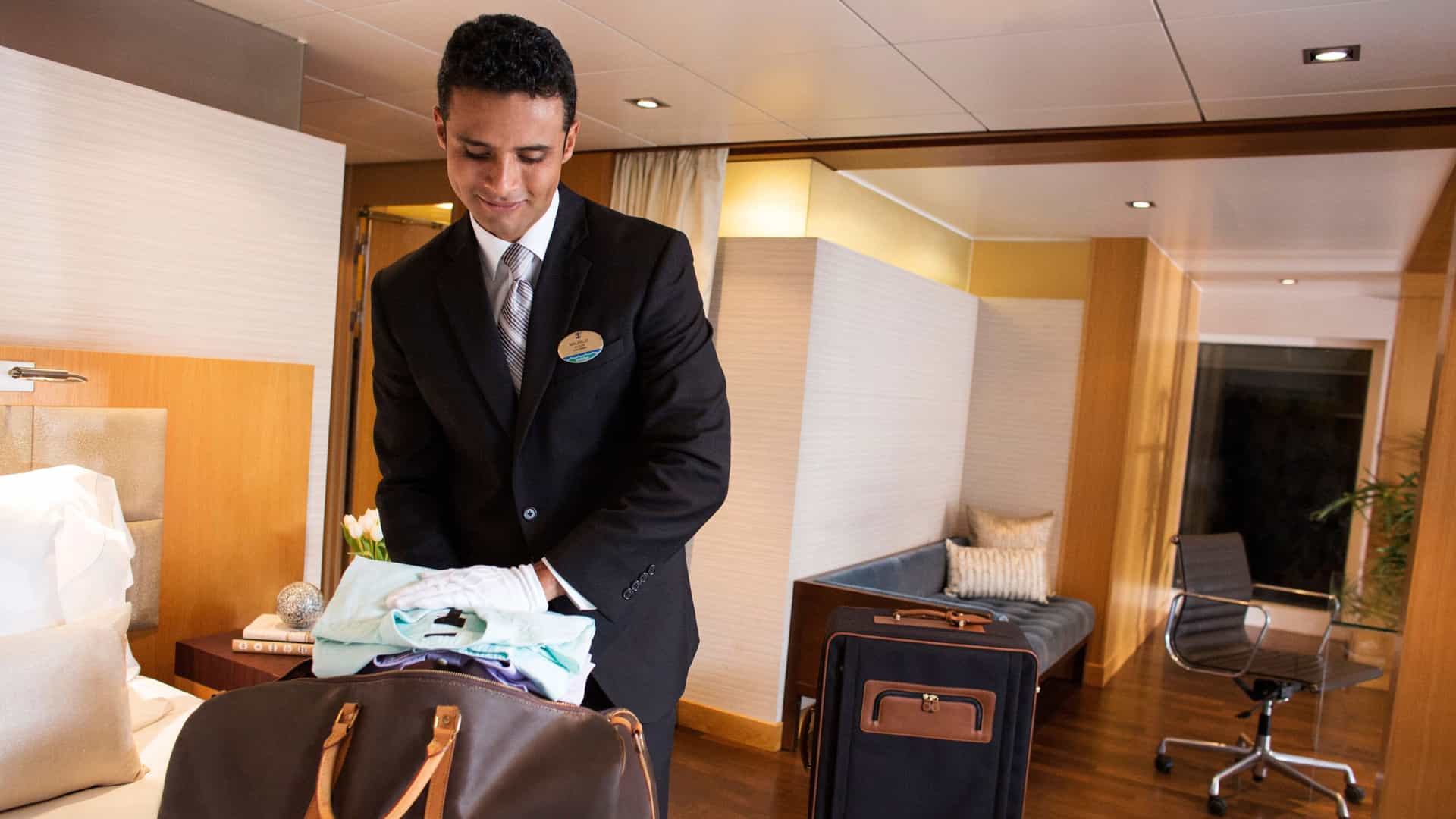 A Royal Genie personal assistant unpacking luggage on a Royal Caribbean cruise.