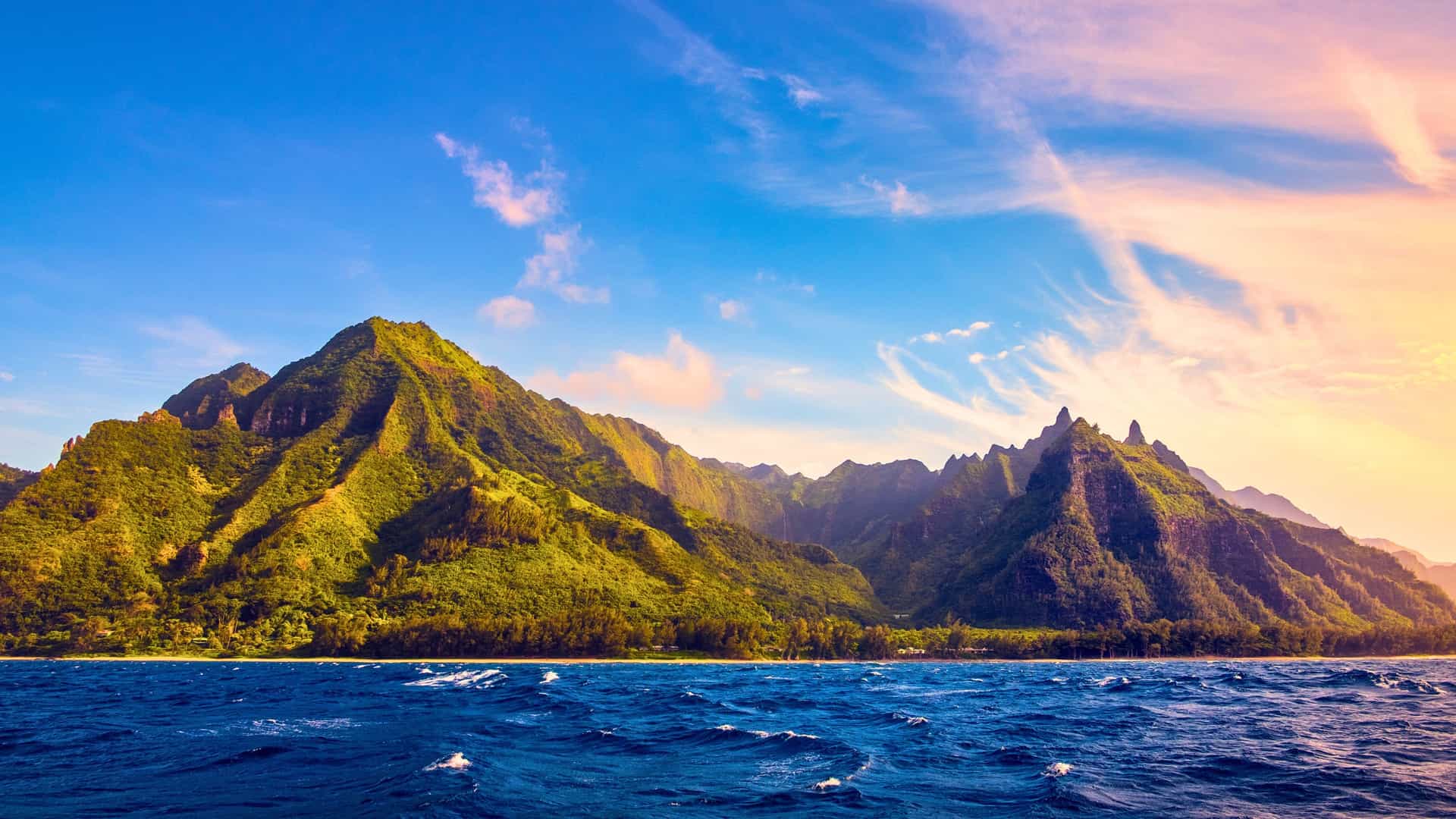 A scenic view of a lush, mountainous island in Hawaii, a tropical destination for Silversea cruises.