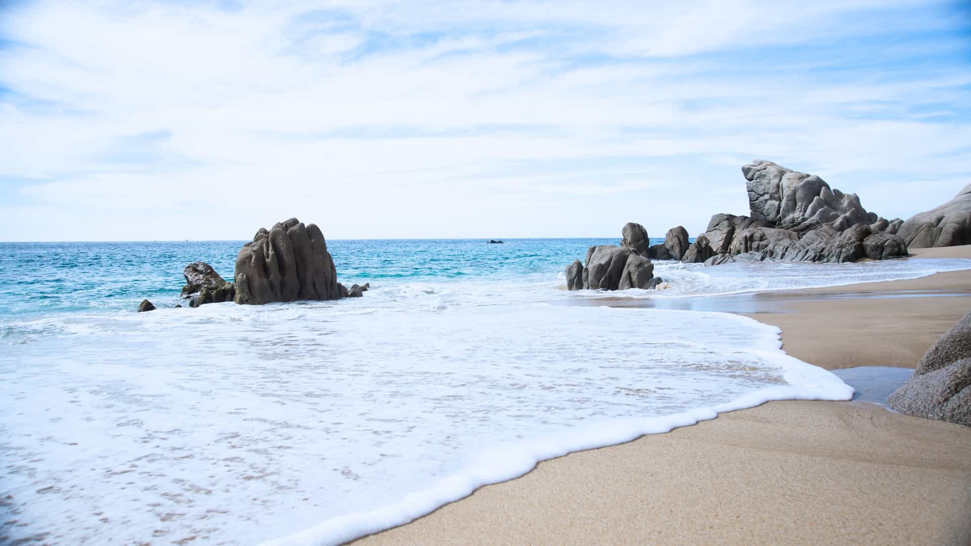 Rocky shoreline and serene beach in Cabo San Lucas, Mexico—an inviting coastal destination on Viking Expedition Cruises in Mexico.