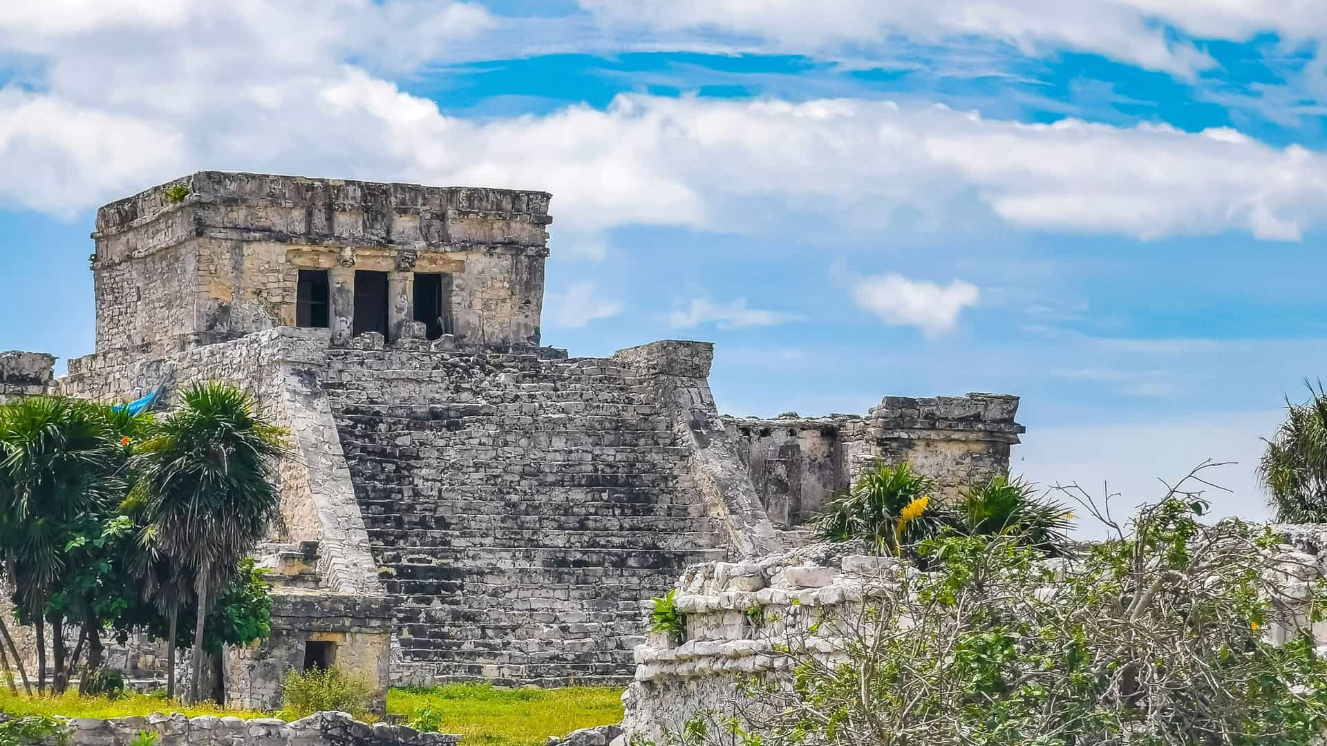 Ancient Mayan ruins at Tulum, Mexico, surrounded by tropical greenery—an enriching cultural stop on Viking Expedition Cruises through the Western Caribbean.