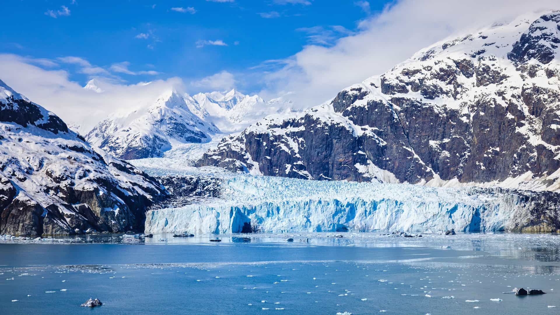 A Viking Ocean cruise ship sailing past a massive, blue glacier in Glacier Bay National Park, Alaska, a popular North American destination.