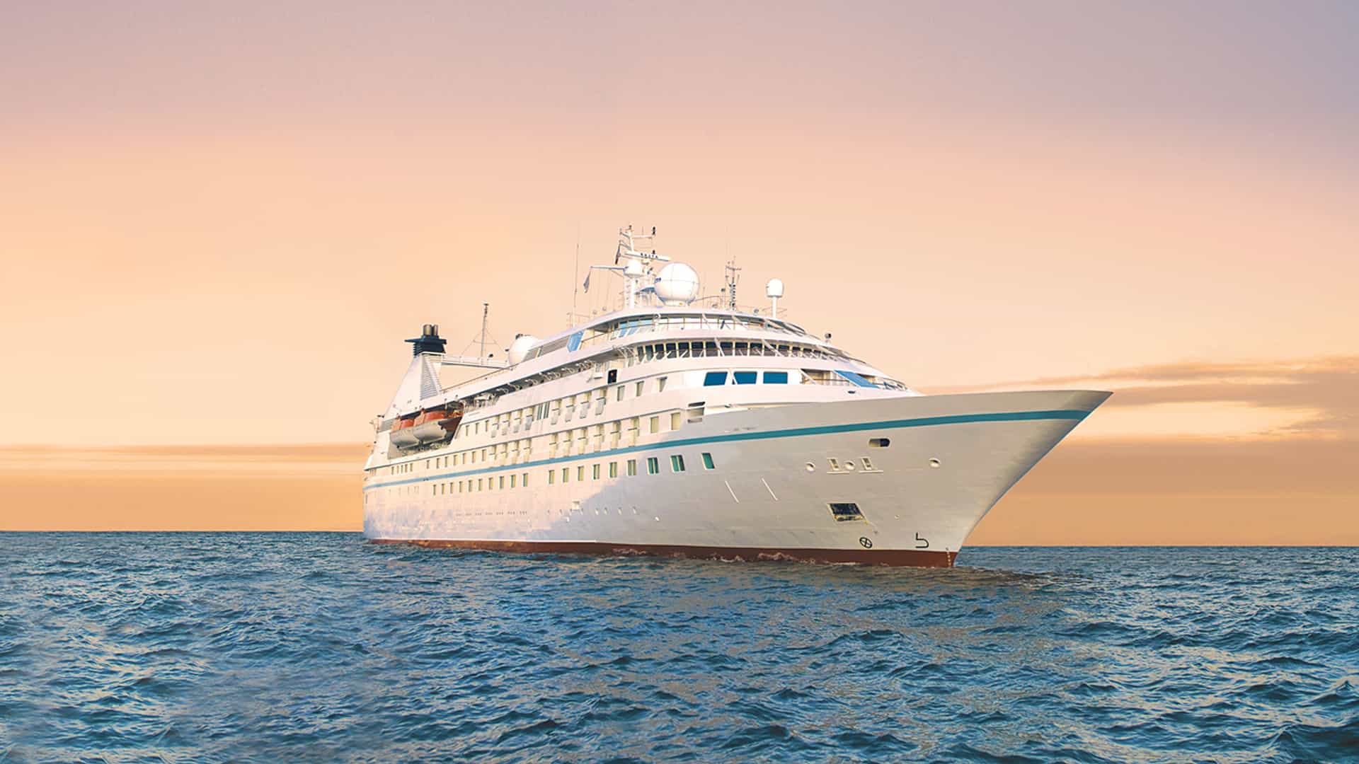 Windstar's Star Pride cruise ship sailing at sunset.