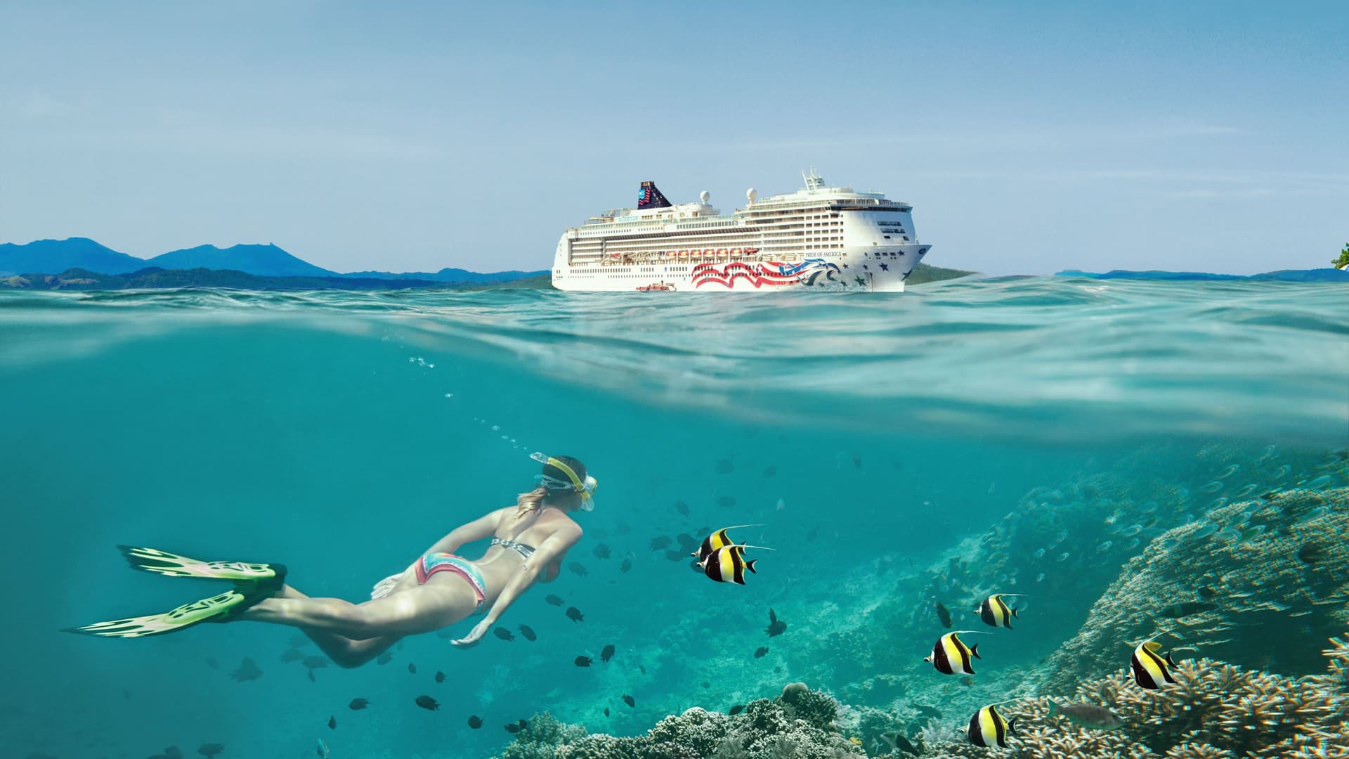 A snorkeler swims over a coral reef with tropical fish in clear Hawaiian water while the Pride of America cruise ship floats on the surface.