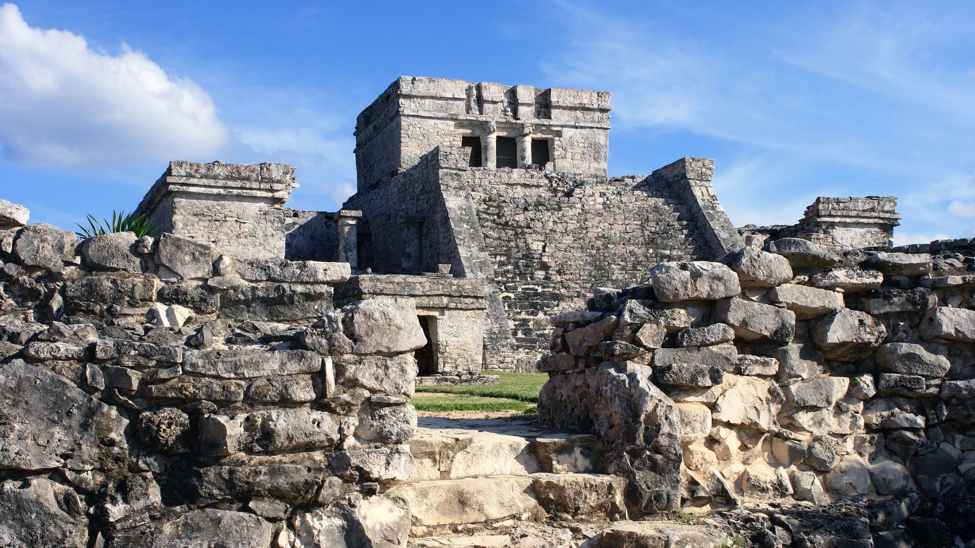 The ancient stone ruins of a majestic Mayan temple or pyramid, featuring historic architecture at an archaeological site in Mexico's Costa Maya region.