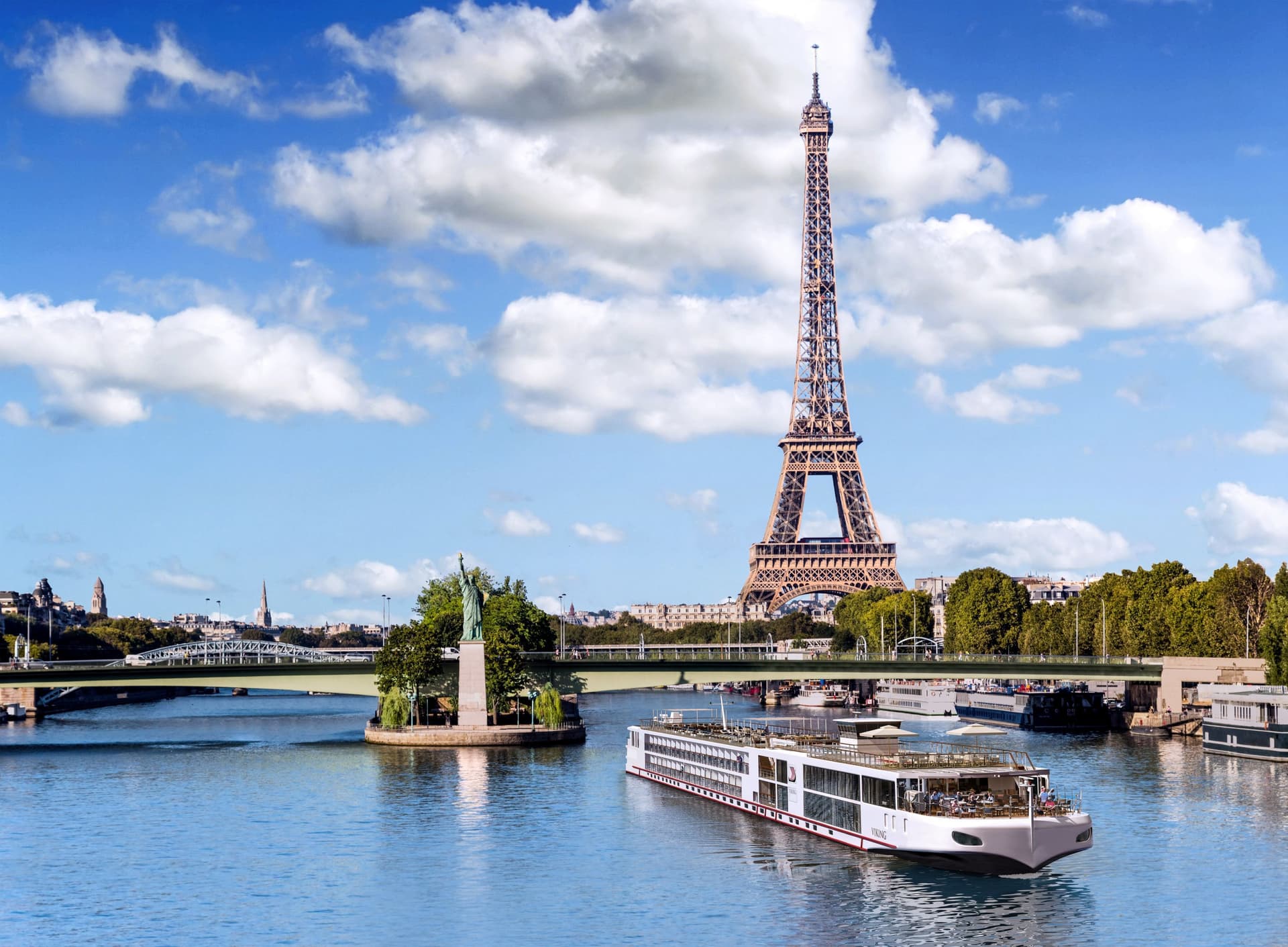 A sleek Viking River long ship sailing with the Eiffel Tower in the background.