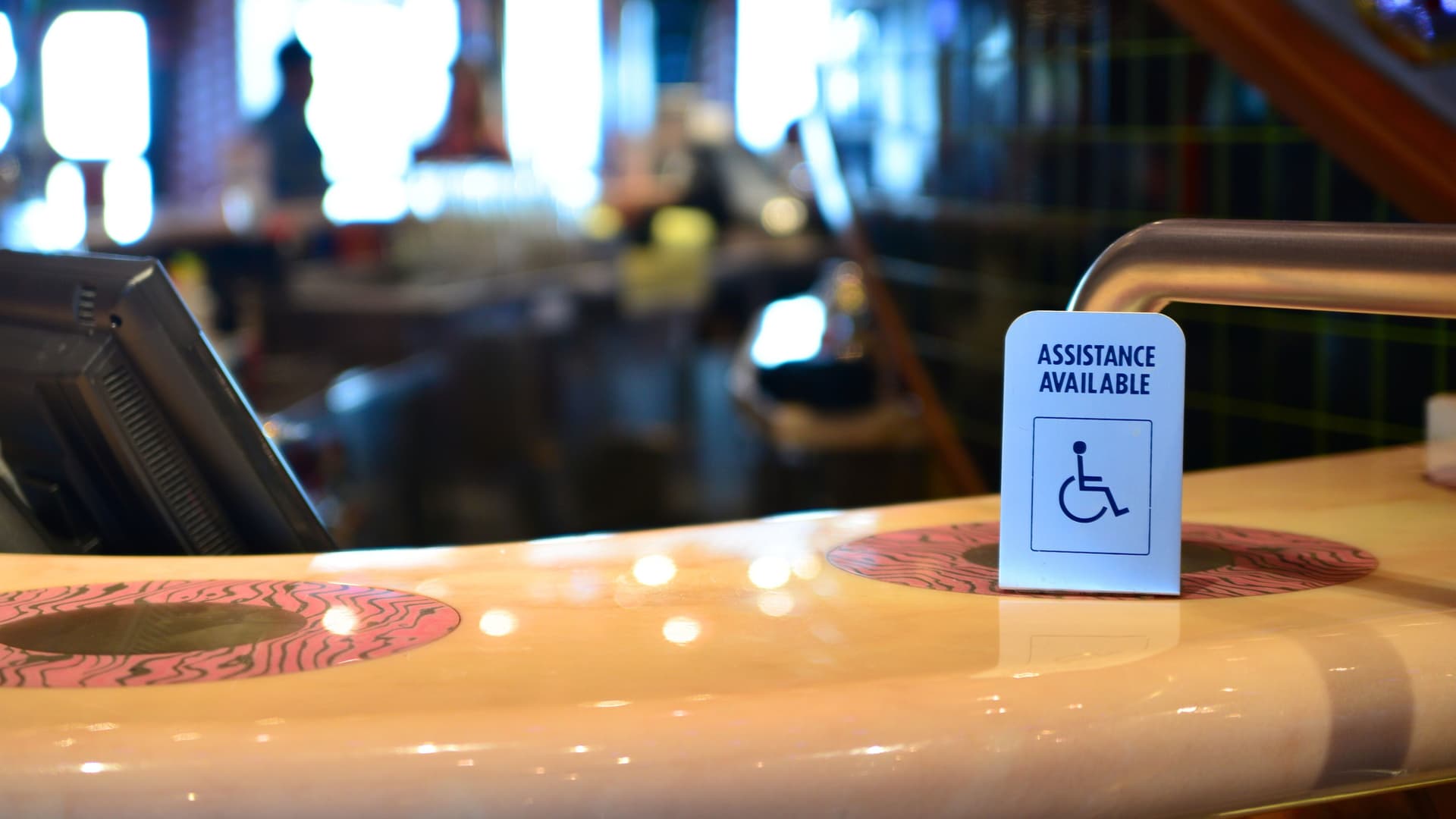 Accessibility assistance available sign on a bar counter aboard a cruise ship.