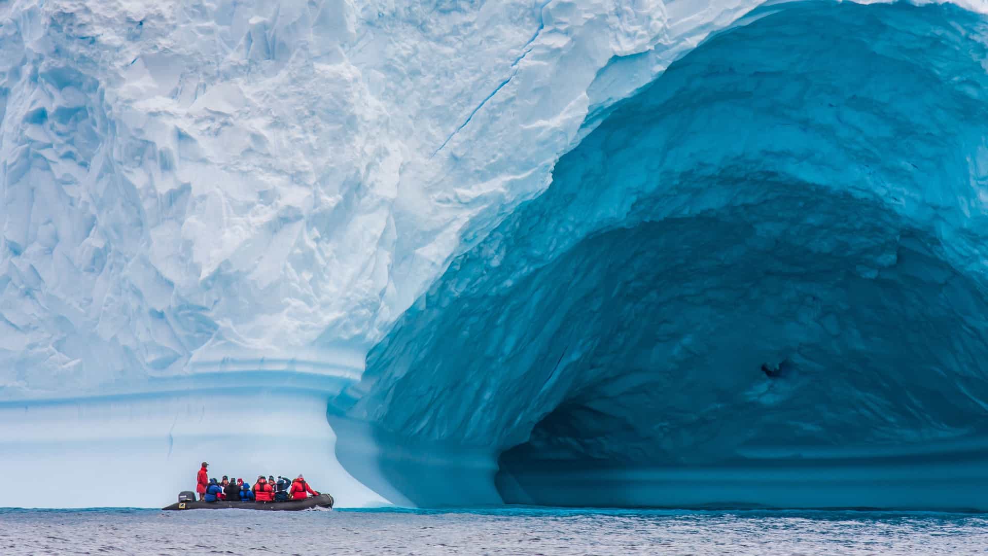 Zodiac in front of enormous iceberg in Antarctica on an adventure cruise.jpg