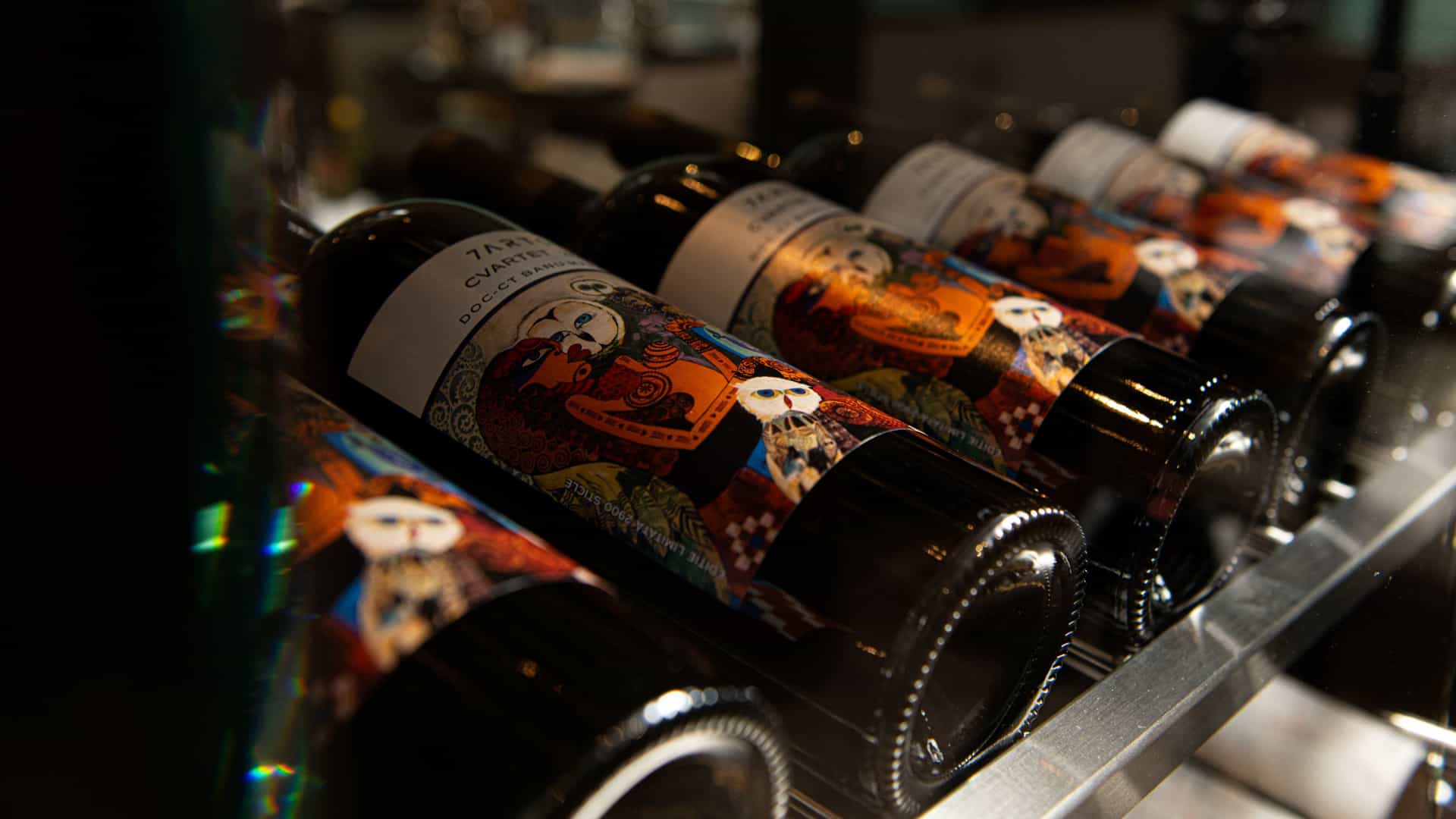 Macro shot of wine bottles lines up inside an Avalon dining room.