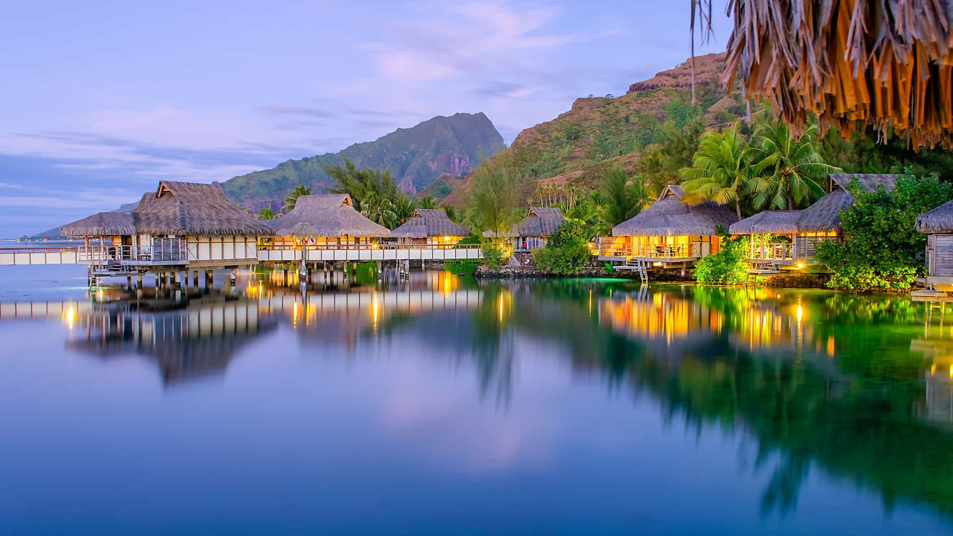 Azamara Cruises: Moorea, French Polynesia - illuminated overwater bungalows and tranquil lagoon, South Pacific/Tahiti destination.