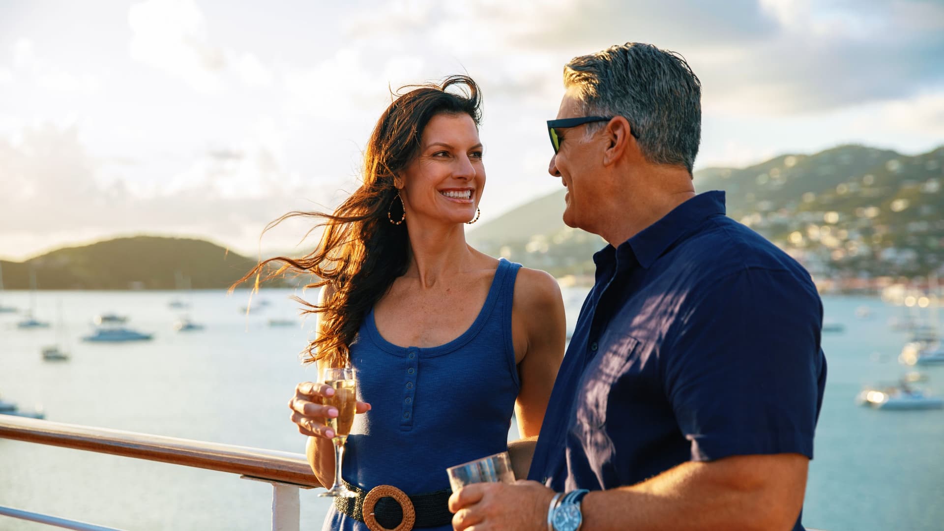 A couple happily enjoying a glass of wine onboard an Azamara cruise in the Caribbean.