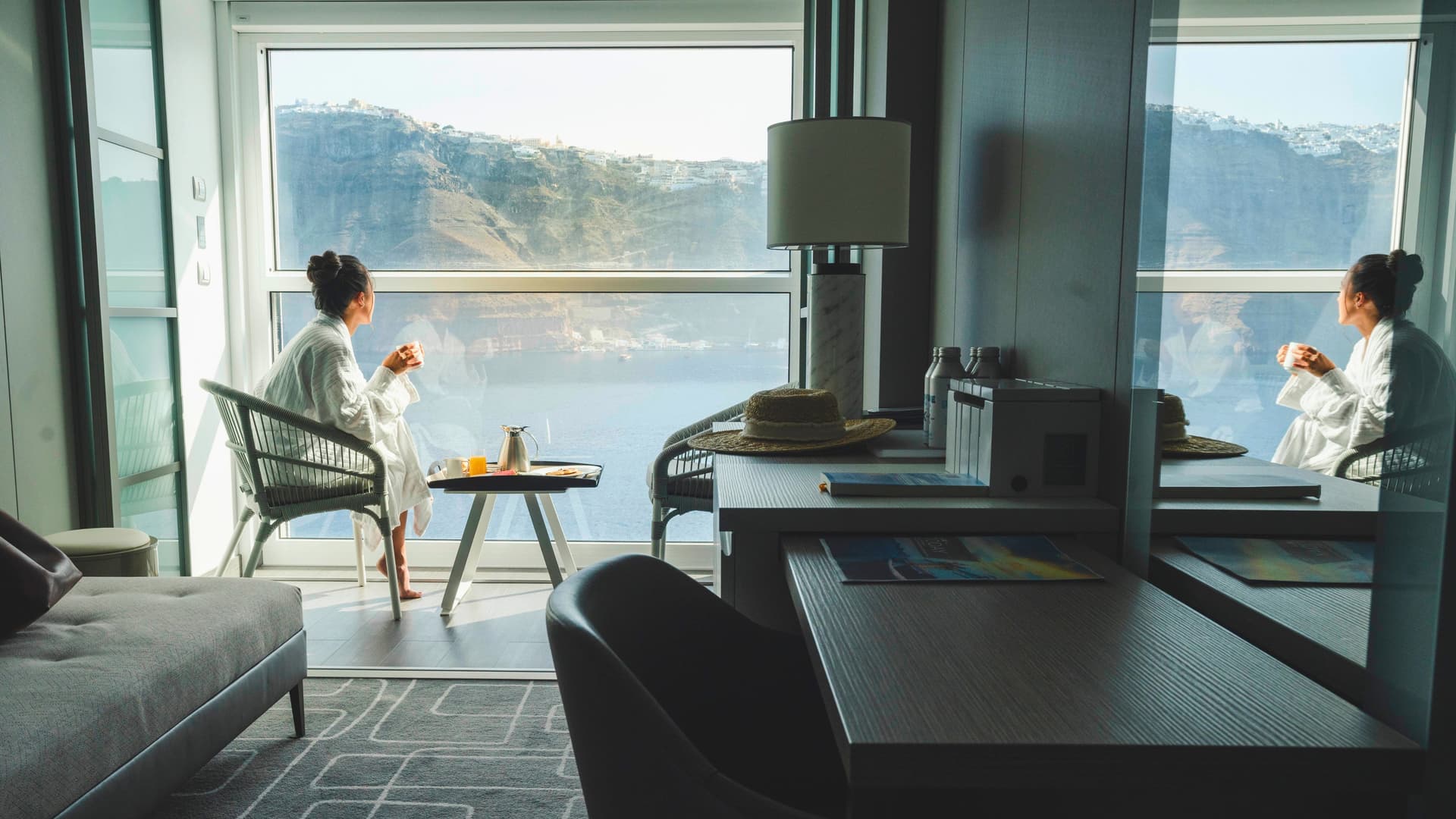 A guest enjoying room service breakfast in an Infinite Veranda stateroom during an Alaska cruise on the Celebrity Apex.