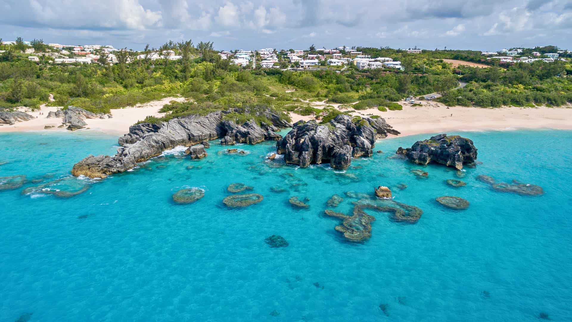 Aerial view of Horseshoe Bay Cove in Bermuda with pink sand, turquoise waters, and rock formations on a Celebrity Cruises itinerary.
