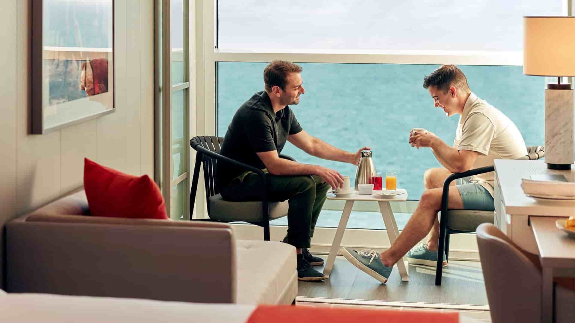 Happy couple enjoying their room service breakfast in their Veranda Suite within The Haven onboard the Celebrity Beyond.