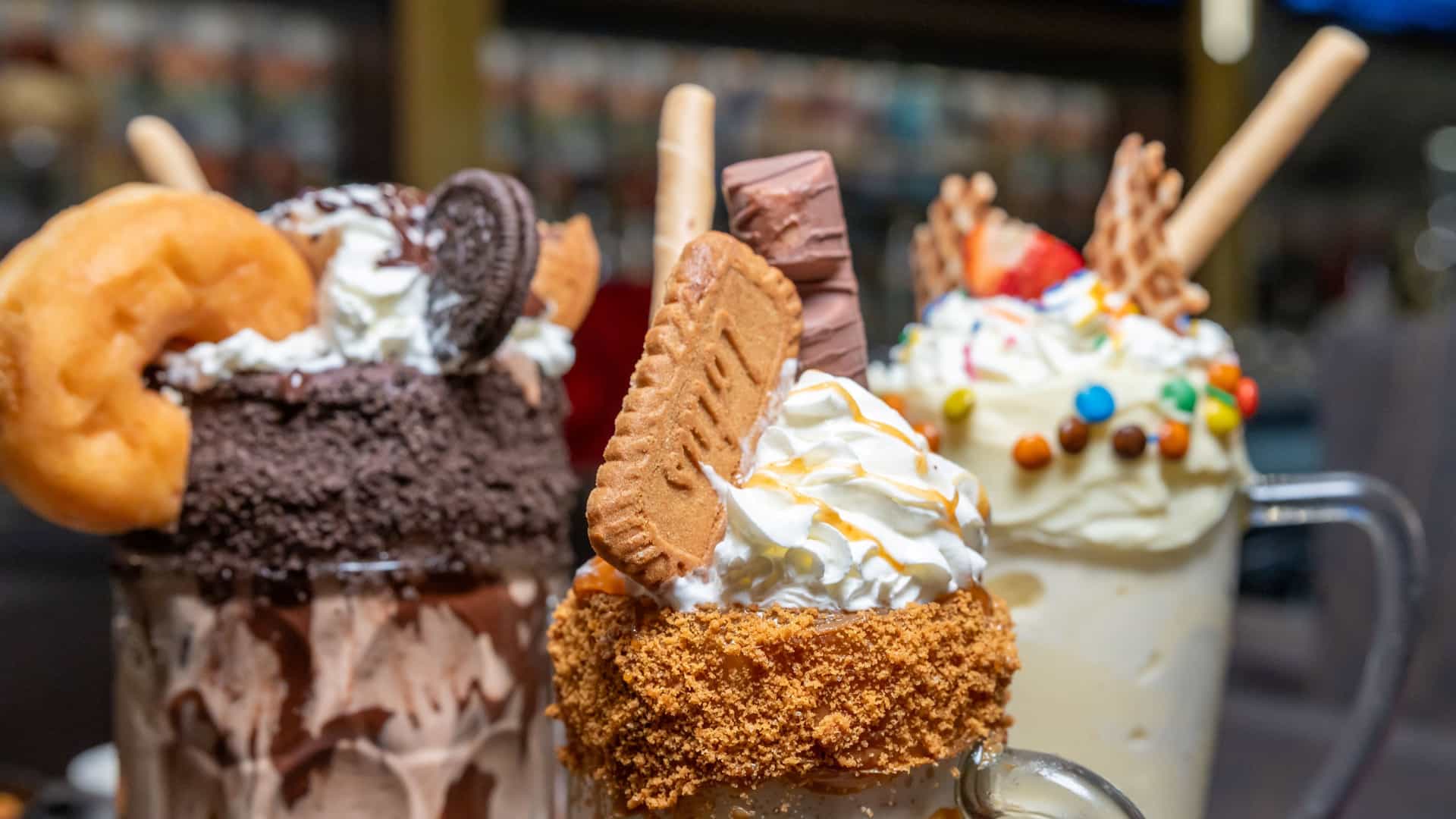 Three over-the-top gourmet milkshakes topped with whipped cream, cookies, a doughnut and wafers at The Parlor.
