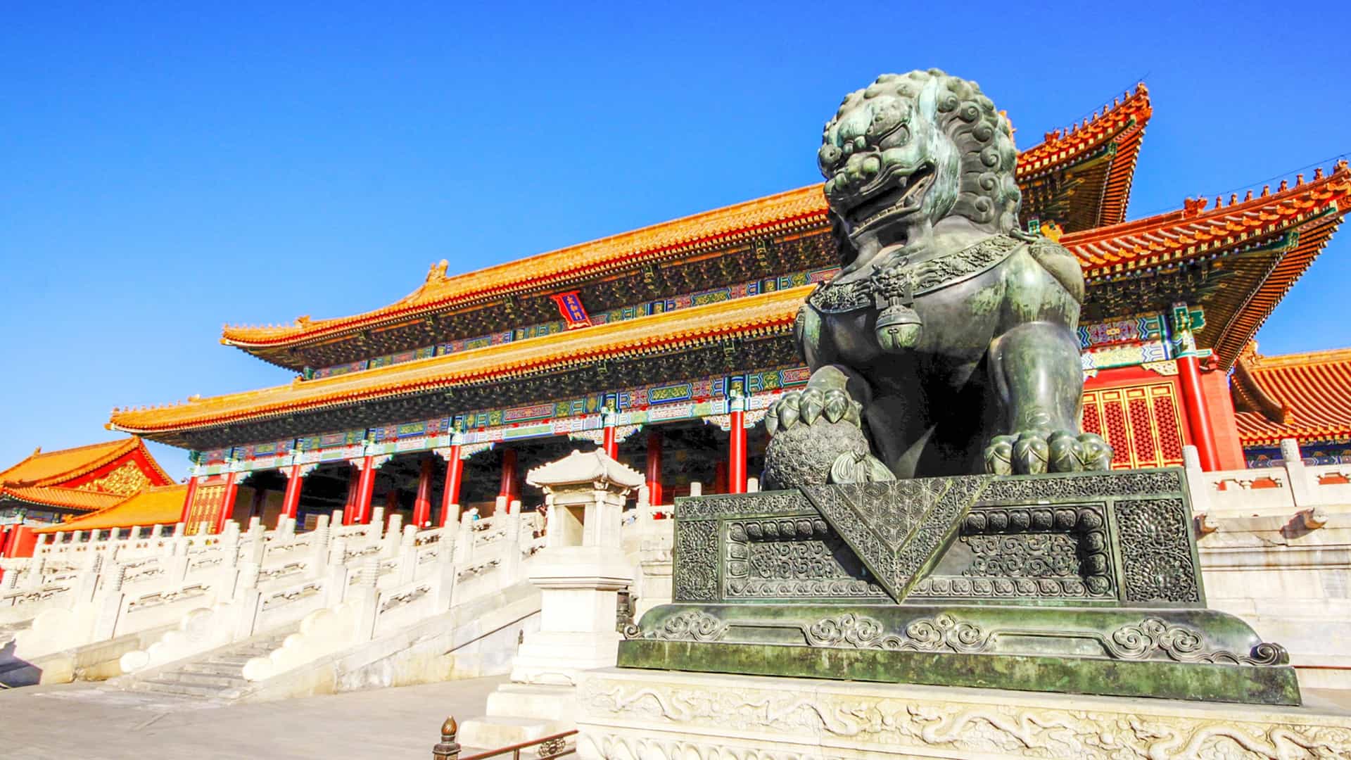 A lion statue stands in front of a temple, showcasing its impressive craftsmanship.
