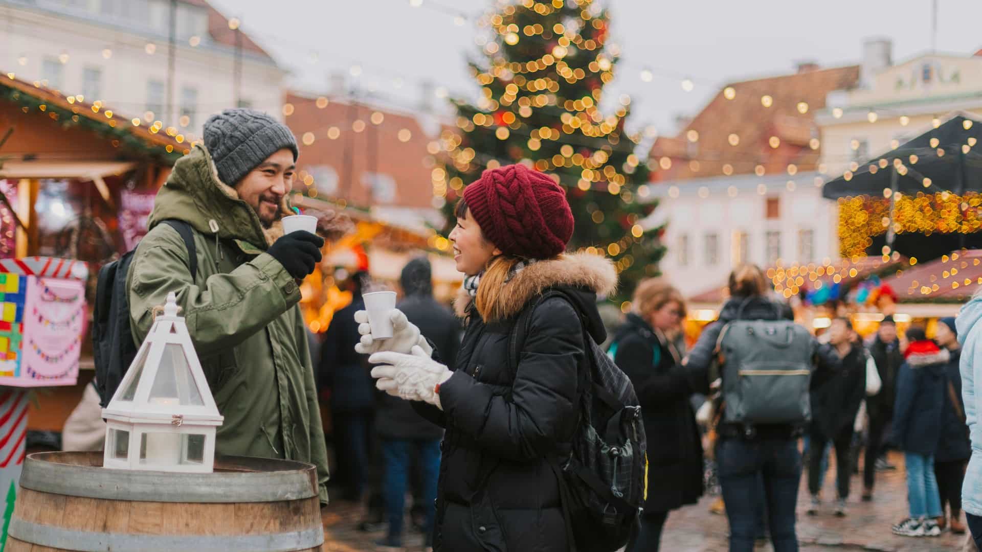 A couple happily trying mulled wine at an European Christmas Market during a cruise shore excursion.