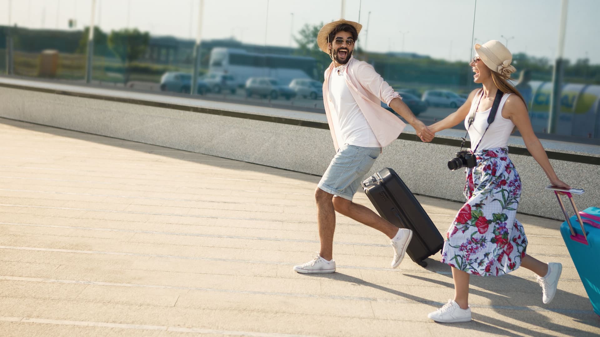 Excited couple running with their suitcases.