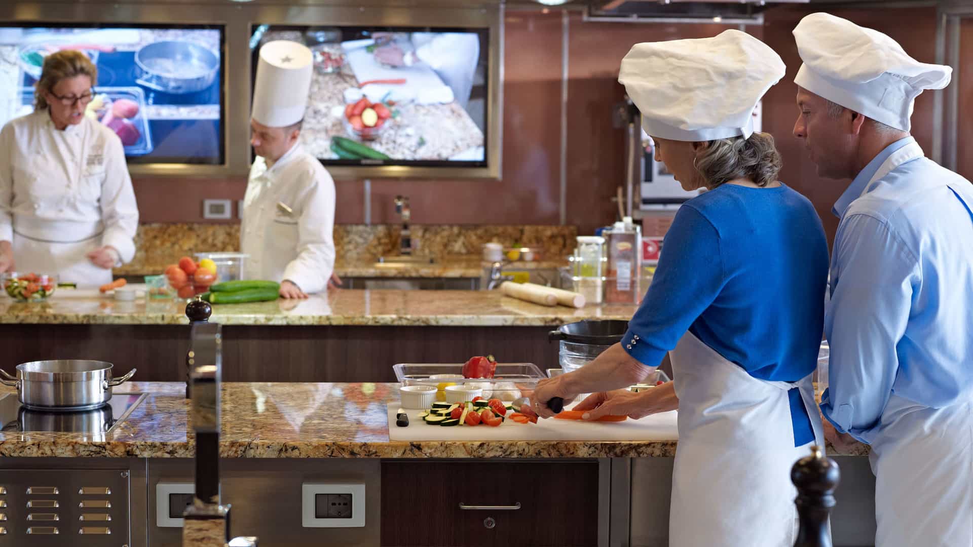 A couple taking a class together at the Culinary Center on an Oceania cruise.