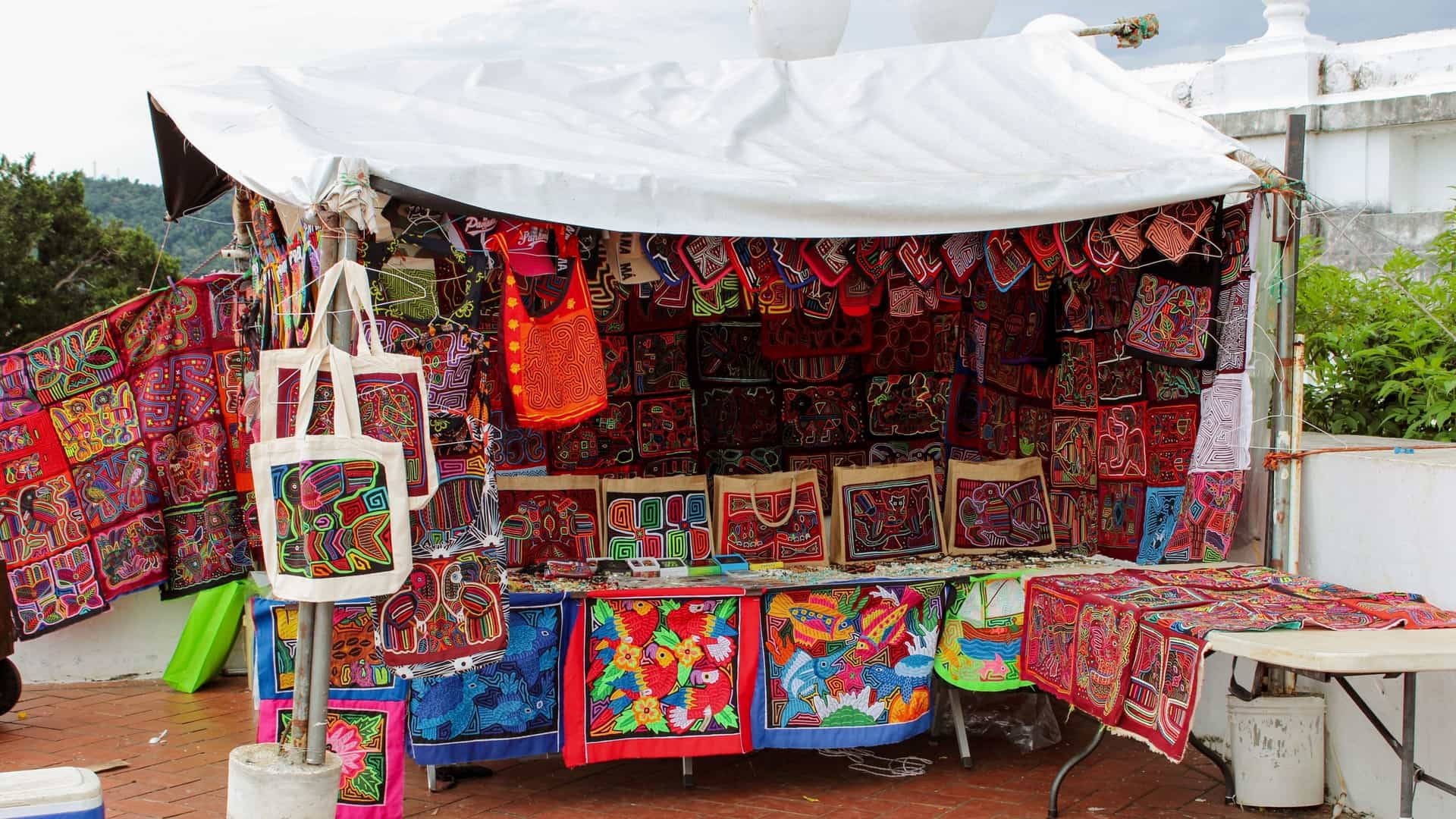 A collection of colorful Panamanian Mola textiles, a traditional handmade layered fabric art by the Kuna people, displayed for sale in Casco Viejo.
