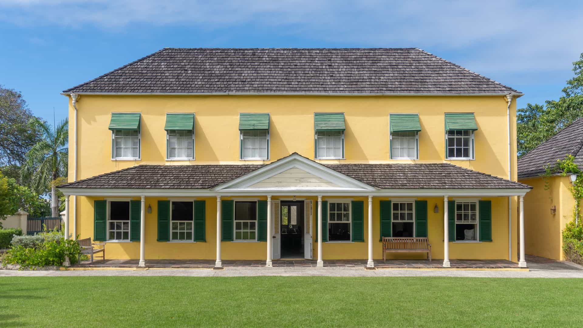 The exterior of the historic George Washington House in Bridgetown, Barbados, a preserved colonial structure with white walls and a red roof.