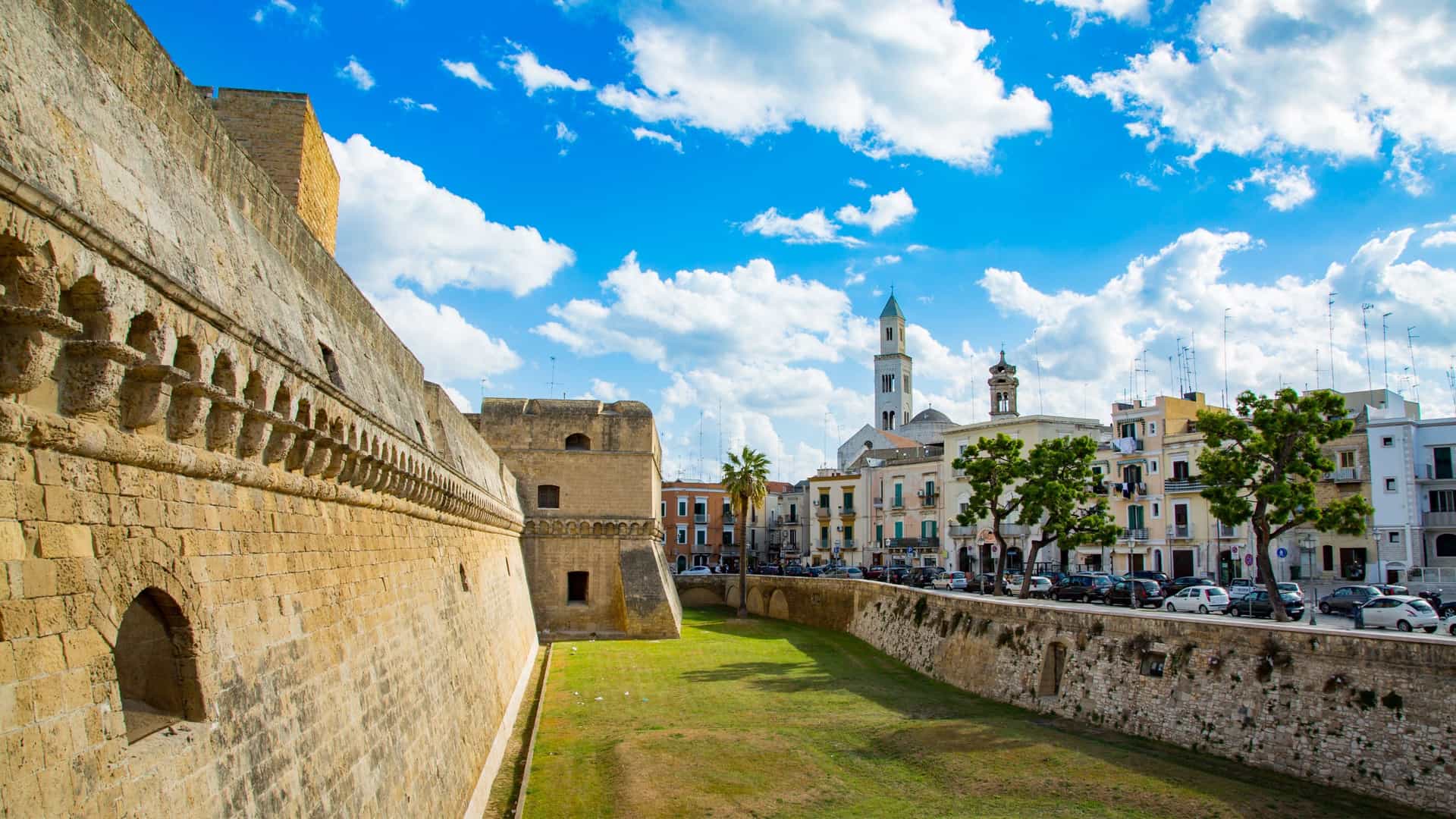 The massive defensive walls and towers of the Swabian Castle (Castello Normanno-Svevo) in Bari, Italy, with a view of the surrounding city.