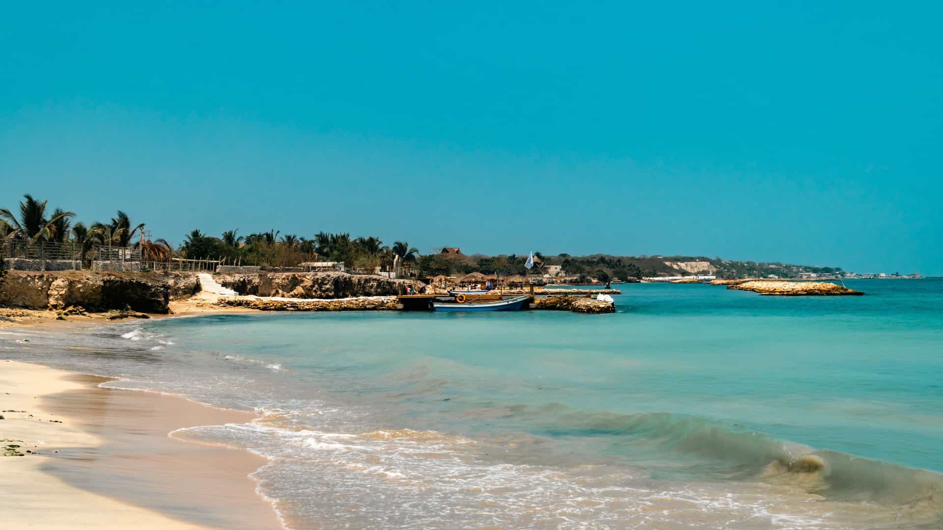 A panoramic view of the Bocagrande skyline in Cartagena, Colombia, featuring modern high rise buildings and resorts, as seen from the beaches of Tierra Bomba Island across the water.