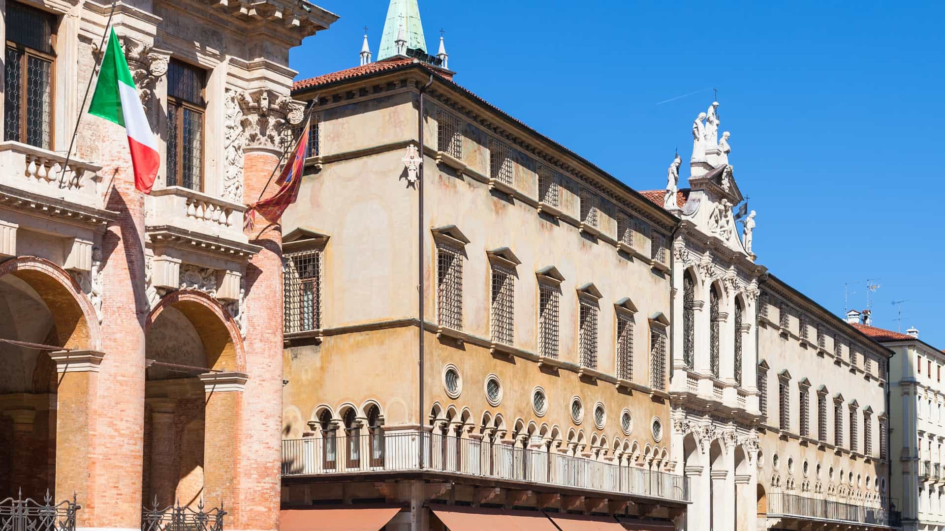 The facade of the Palazzo del Capitaniato, a Renaissance building with red brick columns and white stucco, located in Piazza dei Signori in Vicenza, Italy.