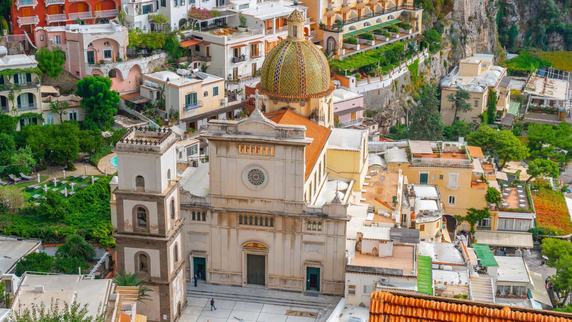 The Church of Santa Maria Assunta in Positano, Italy, is a key landmark of the town. Its distinctive majolica tiled dome, with yellow, green, and blue colors, is a prominent feature of the Positano skyline. The church, which has a baroque interior, houses a 13th century Byzantine icon of a Black Madonna and Child above the main altar.