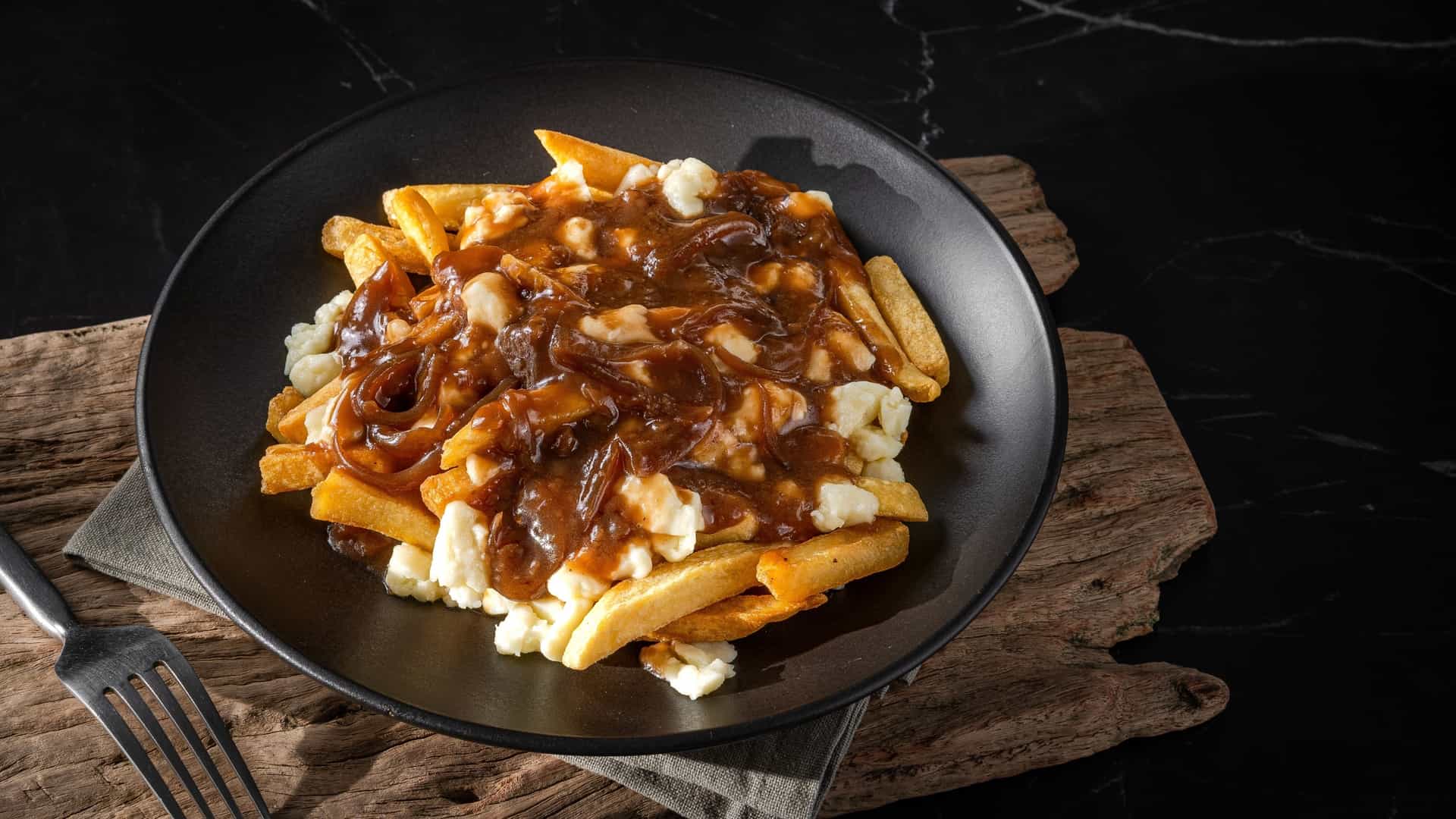 A serving of poutine, the traditional Canadian dish featuring french fries topped with cheese curds and brown gravy, as might be served in a local restaurant in Churchill, Manitoba.
