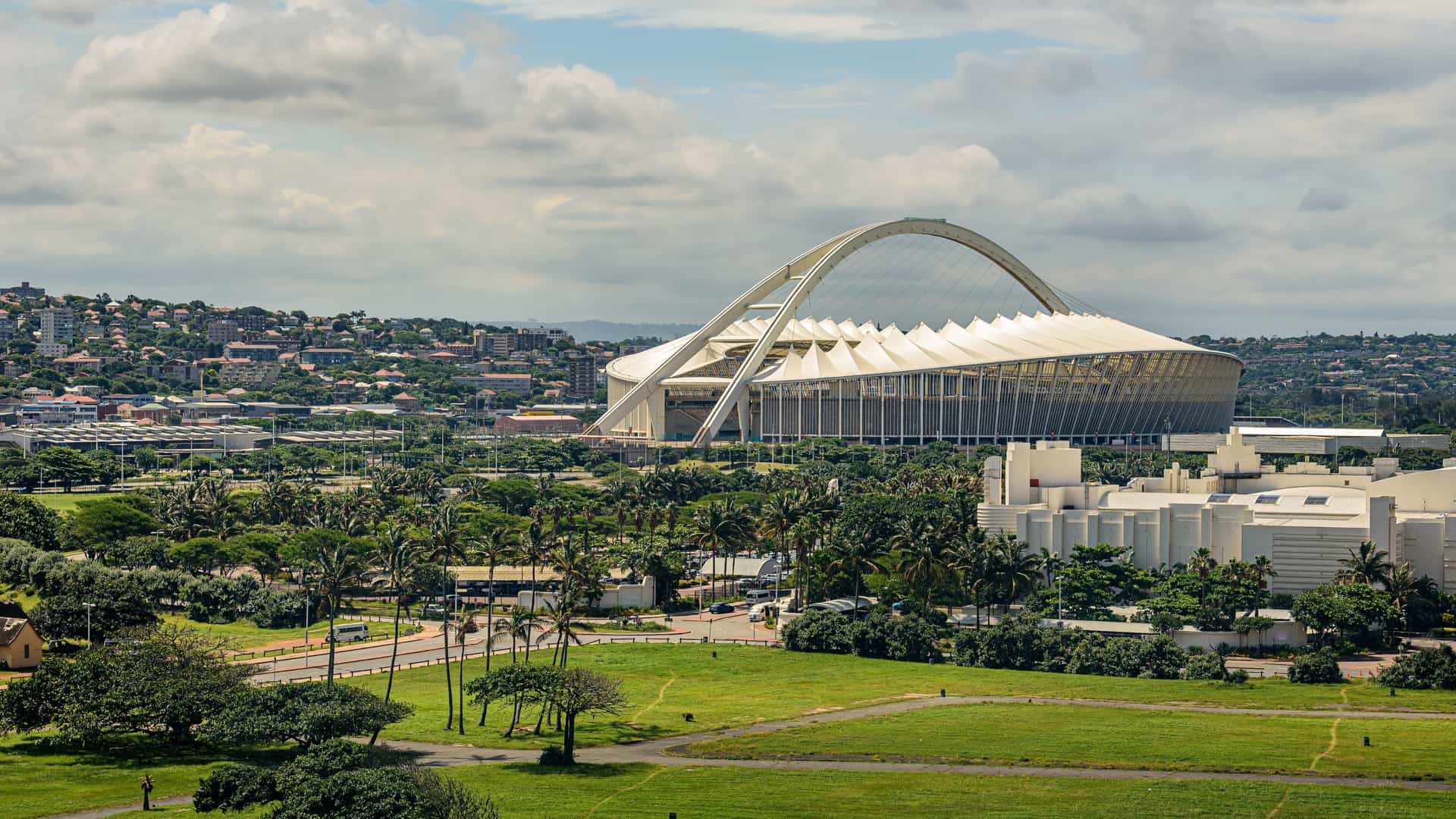 The distinctive white arch of the Moses Mabhida Stadium in Durban, South Africa, which frames the stadium's roof and allows visitors to ride a sky car for panoramic views of the city.