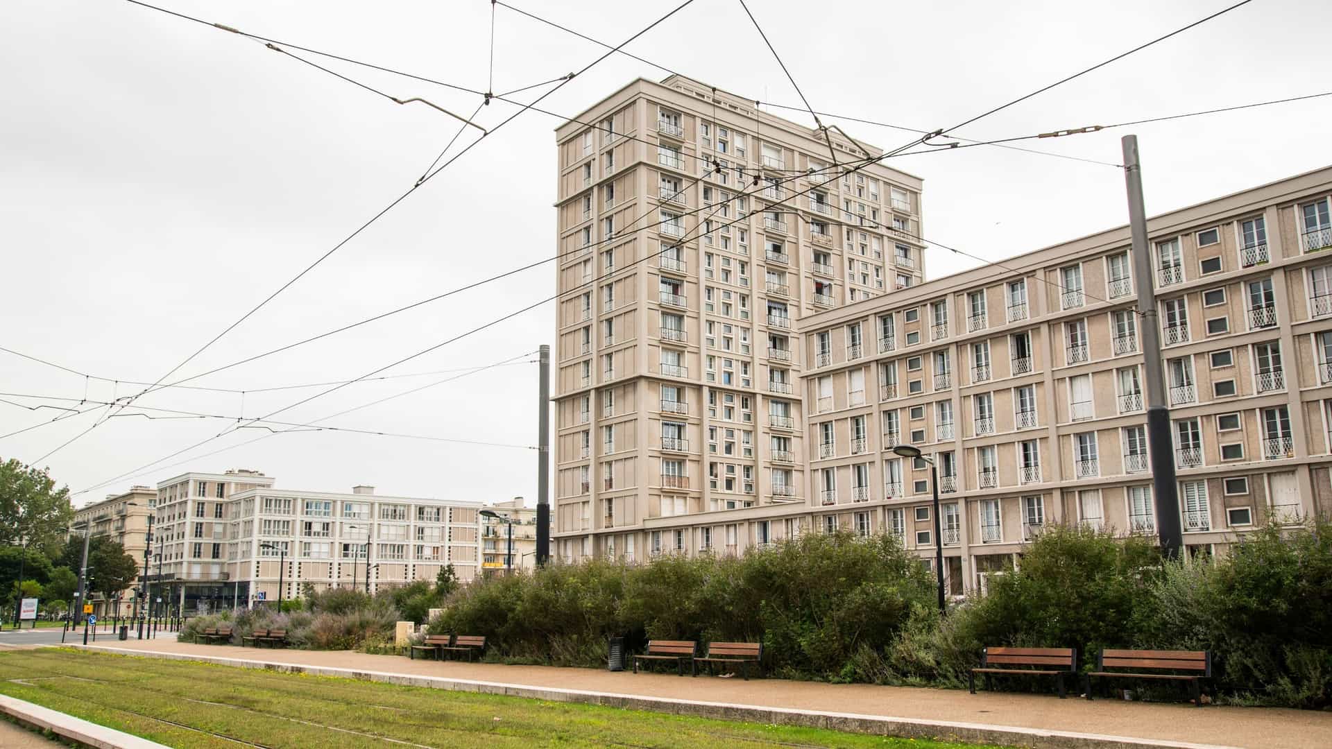 An exterior view of Modernist residential architecture in Le Havre, France, known for its post-WWII reconstruction by Auguste Perret. The image typically shows a large-scale, functionalist building made of reinforced concrete, characterized by a grid of repetitive windows and geometric, often boxy, shapes that reflect the socialist-modernist or Brutalist style of the era. The architecture emphasizes verticality and clean lines.