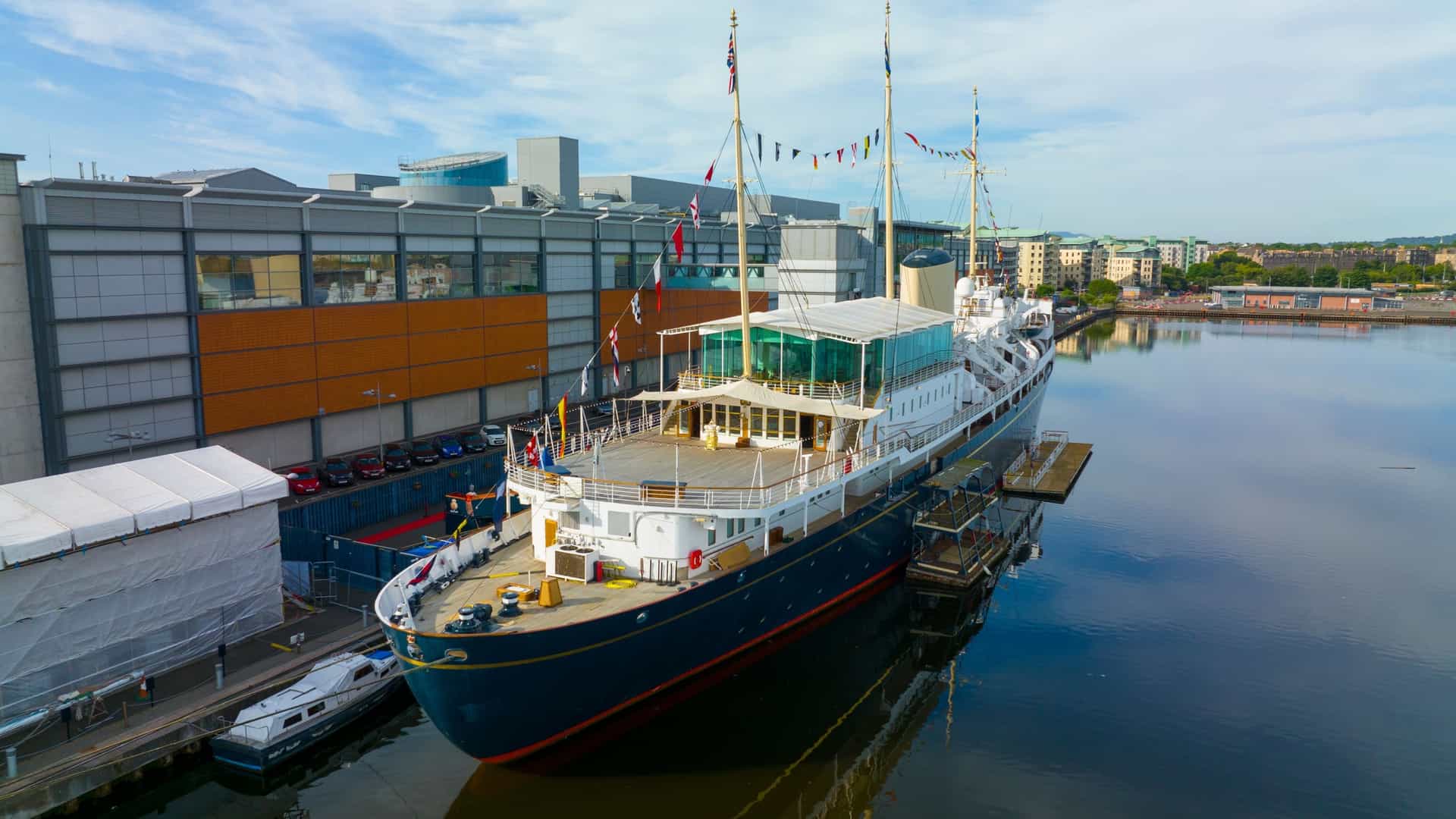 An aerial view of the Royal Yacht Britannia, the former floating palace of the British monarchy, docked permanently as a museum ship in the historic Port of Leith in Edinburgh, Scotland.