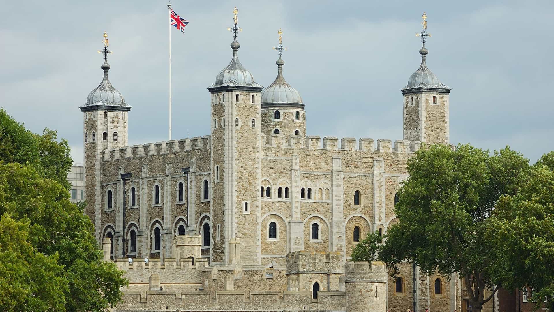 The Tower of London, a historic fortress and UNESCO World Heritage site, is located on the north bank of the River Thames in London, England. The image shows the castle complex, including the central White Tower, which was built by William the Conqueror in 1078. The fortress has served various purposes throughout its history, including a royal palace, prison, and treasury.