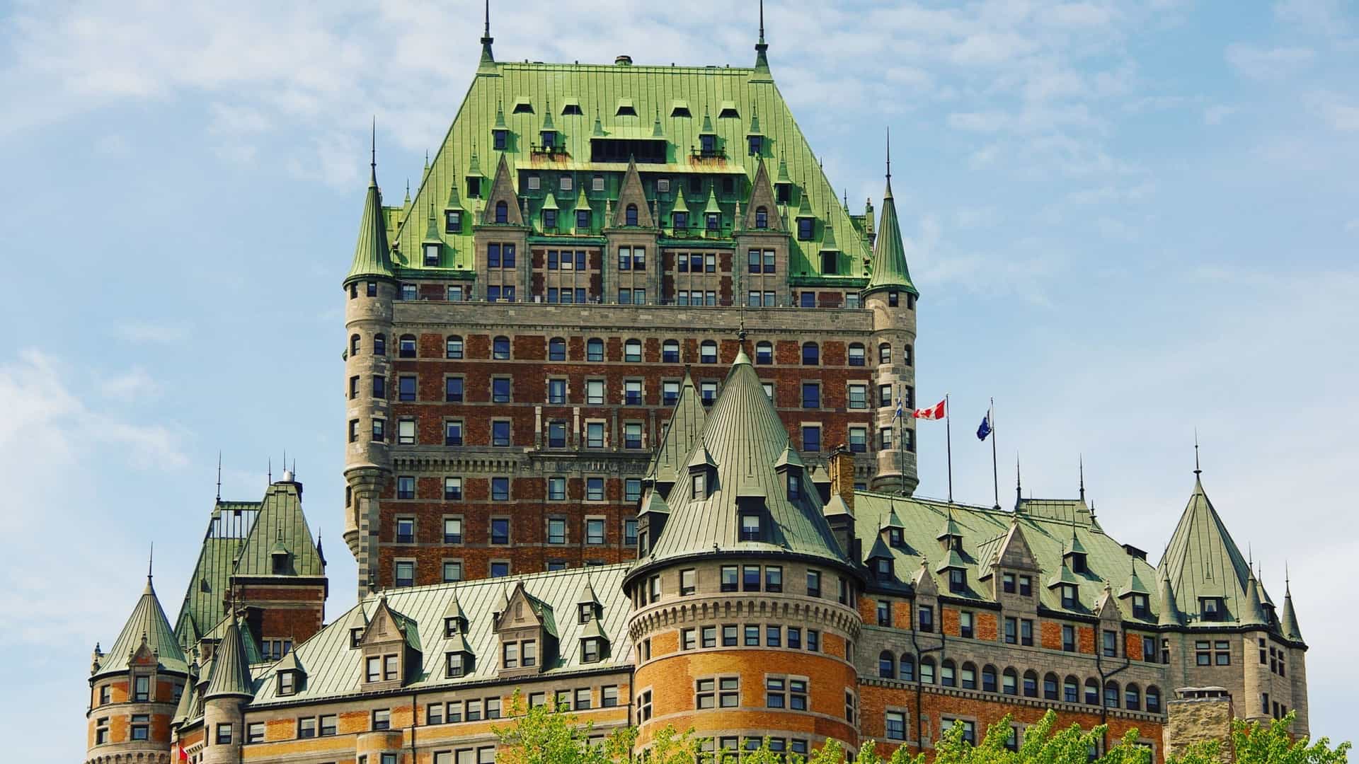A close up view of the Fairmont Le Château Frontenac in Quebec City, Canada, showcasing its distinctive Châteauesque architecture with multiple towers, turrets, and a prominent copper green roof, as the historic hotel stands high on the cliffs of Old Quebec.