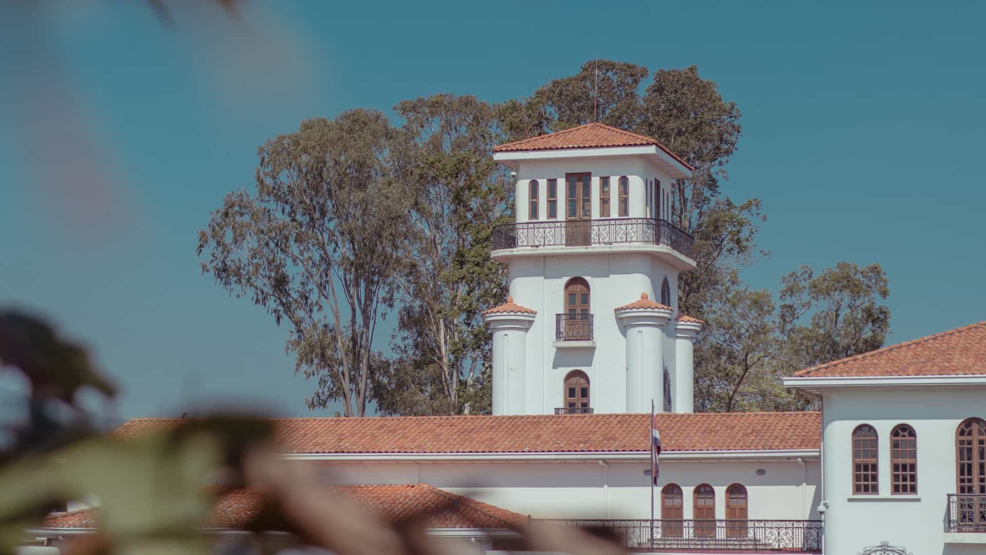 A close up detail of a white tower rising from the Museum of Costa Rican Art in San José, Costa Rica, set against a clear, sunny, cloudless blue sky.