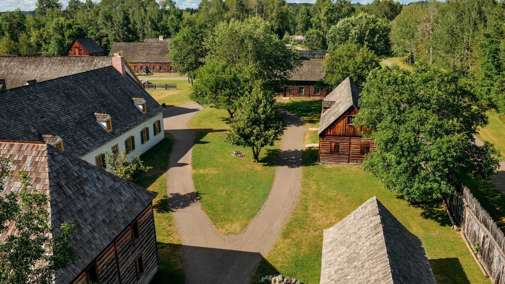 A view of the reconstructed historical log buildings and palisade walls of Fort William Historical Park in Thunder Bay, Ontario. The site depicts the 19th century inland headquarters of the North West Company fur trade.