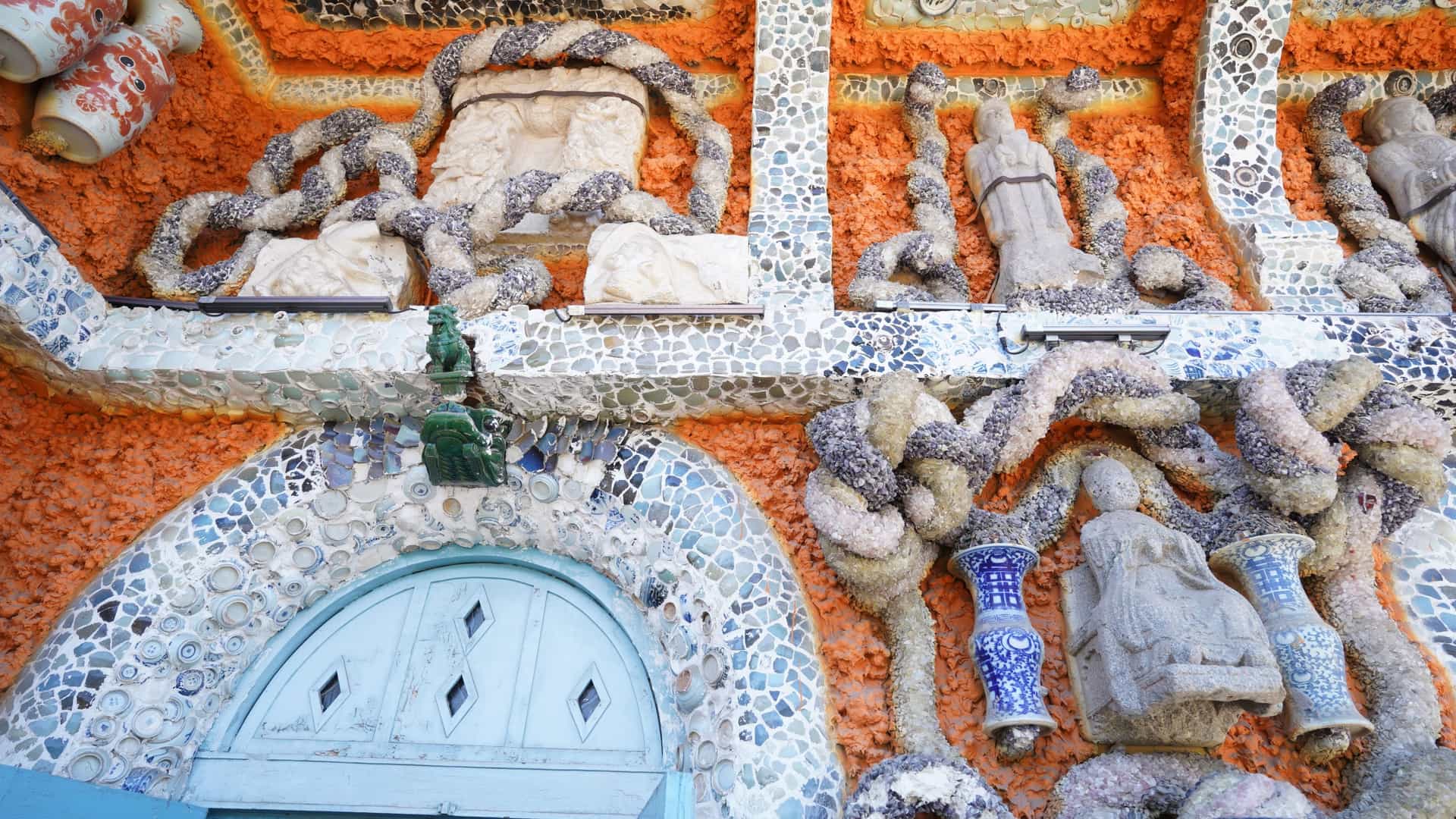 A close up view of the Porcelain House (Cífángzi) in Tianjin, China, showing the exterior of the historic French style building completely covered in a dense, elaborate mosaic made from hundreds of millions of broken pieces of colorful and patterned ancient Chinese porcelain and ceramic artifacts.