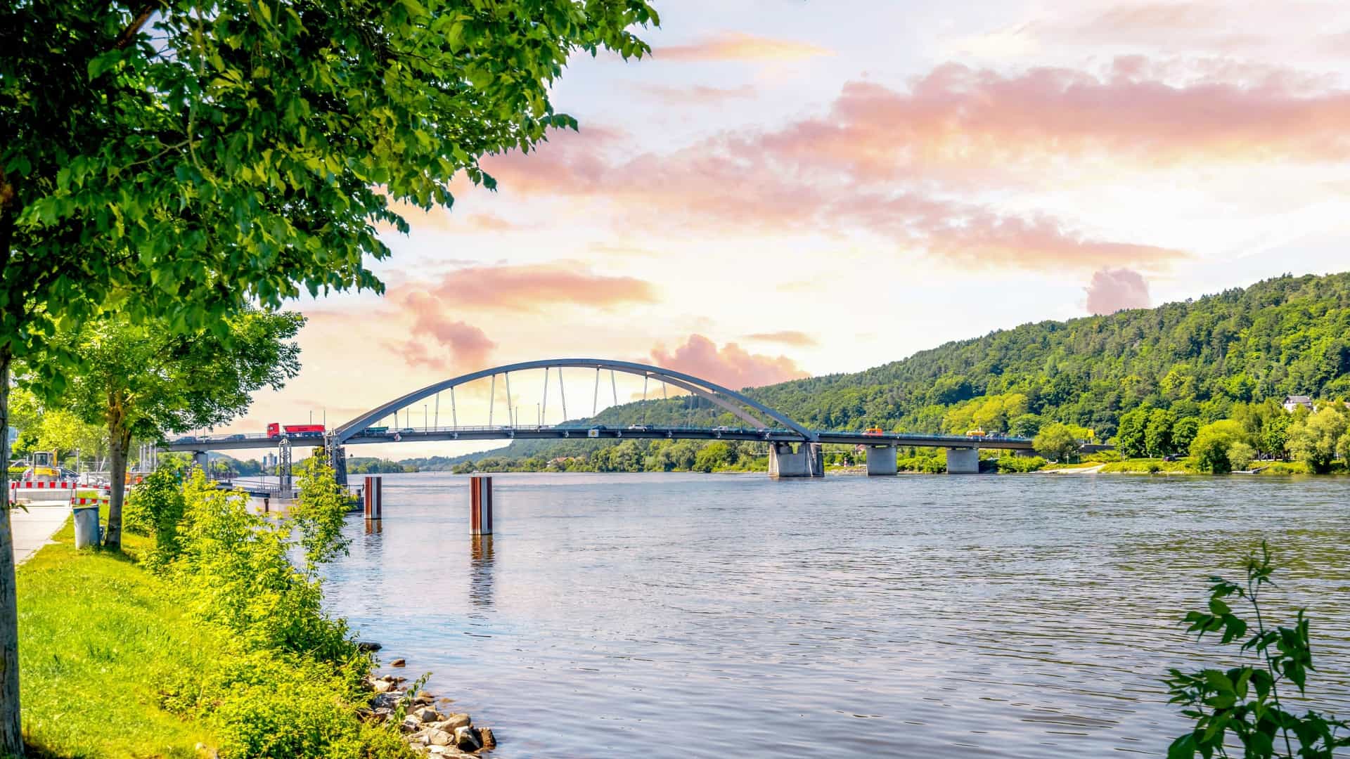 A scenic view of the historic old town of Vilshofen an der Donau, Germany, located on the Danube River, showcasing traditional Bavarian architecture and a waterfront promenade, suggesting a relaxing riverside walk.