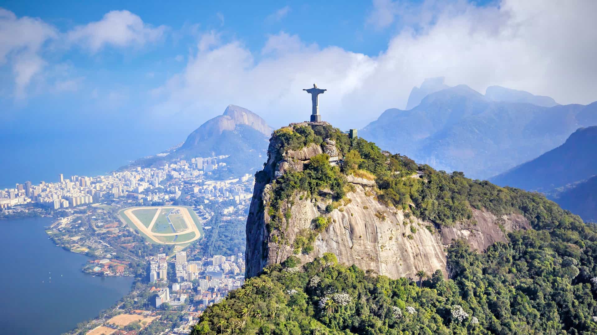 Explora journey aerial view of the Christ the Redeemer statue atop Corcovado mountain overlooking Rio de Janeiro, South America.