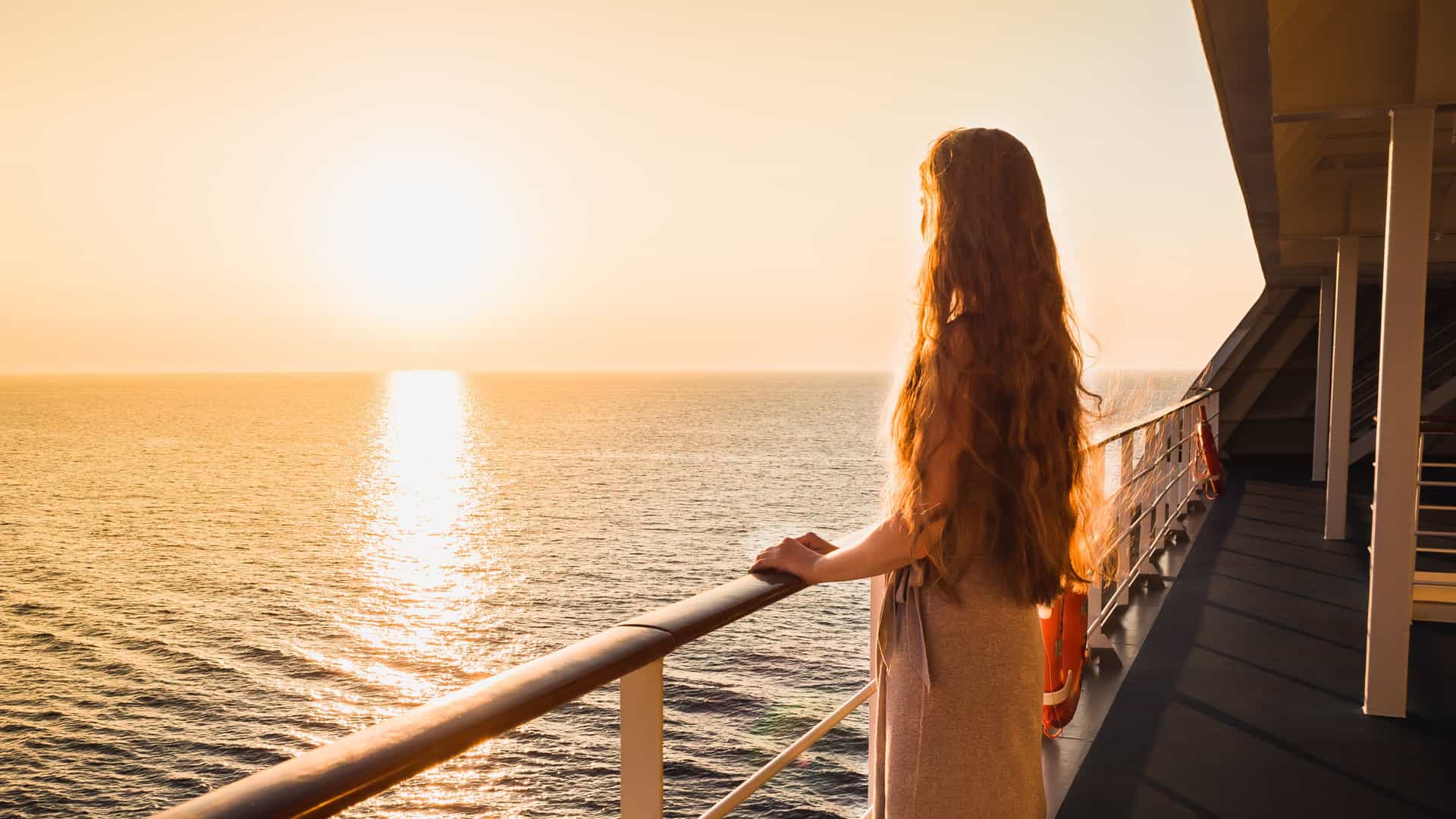 Explora journey view of a passenger looking out at the open ocean sunset from the deck of a cruise ship during a transatlantic crossing.