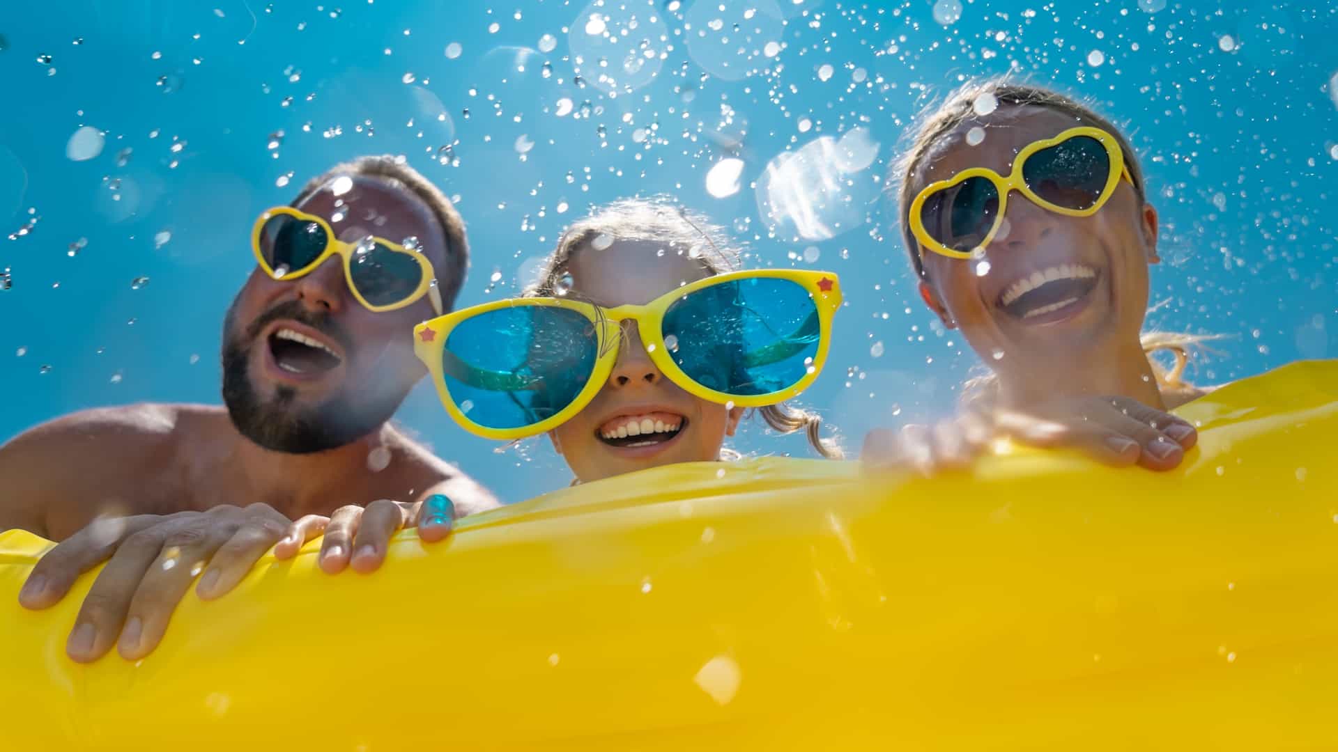 A family leaning on a yellow floaty while on a cruise.