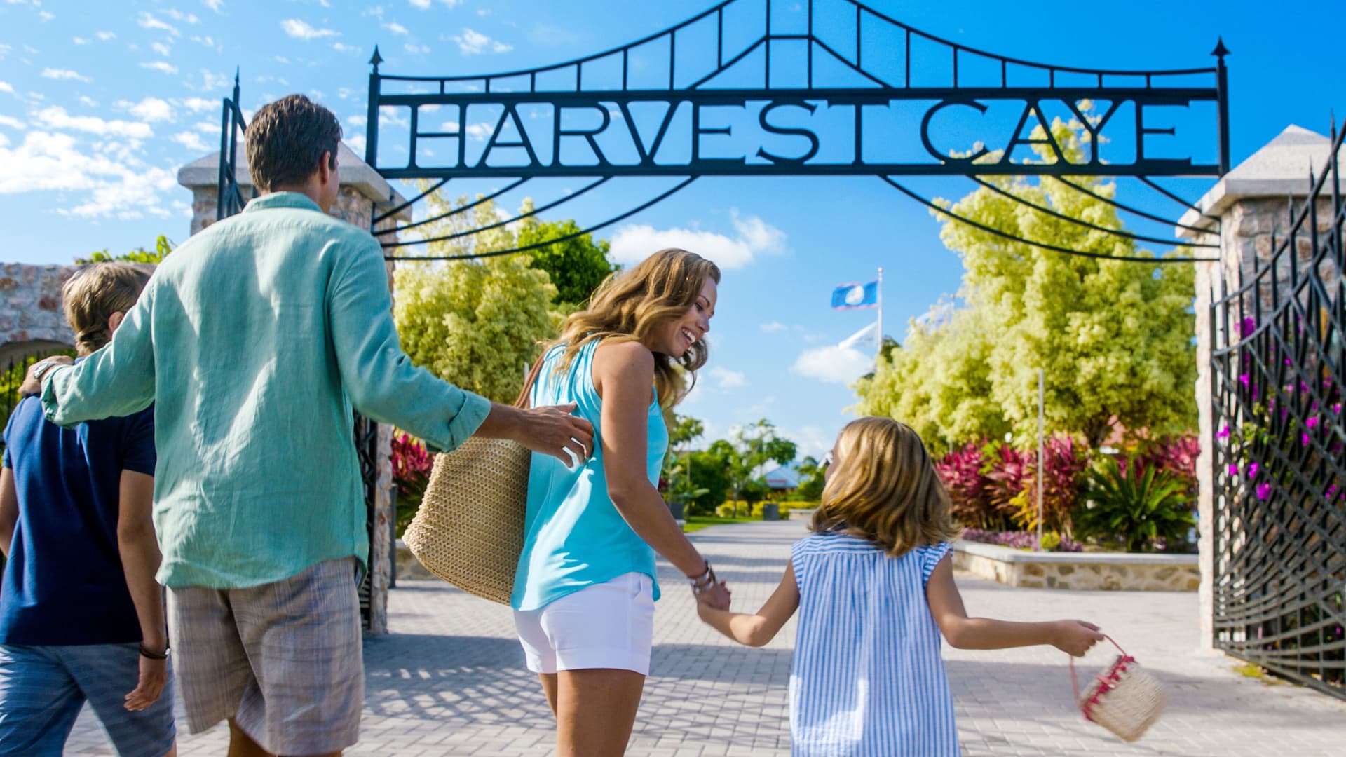 Family walking through the main gate at Harvest Caye.